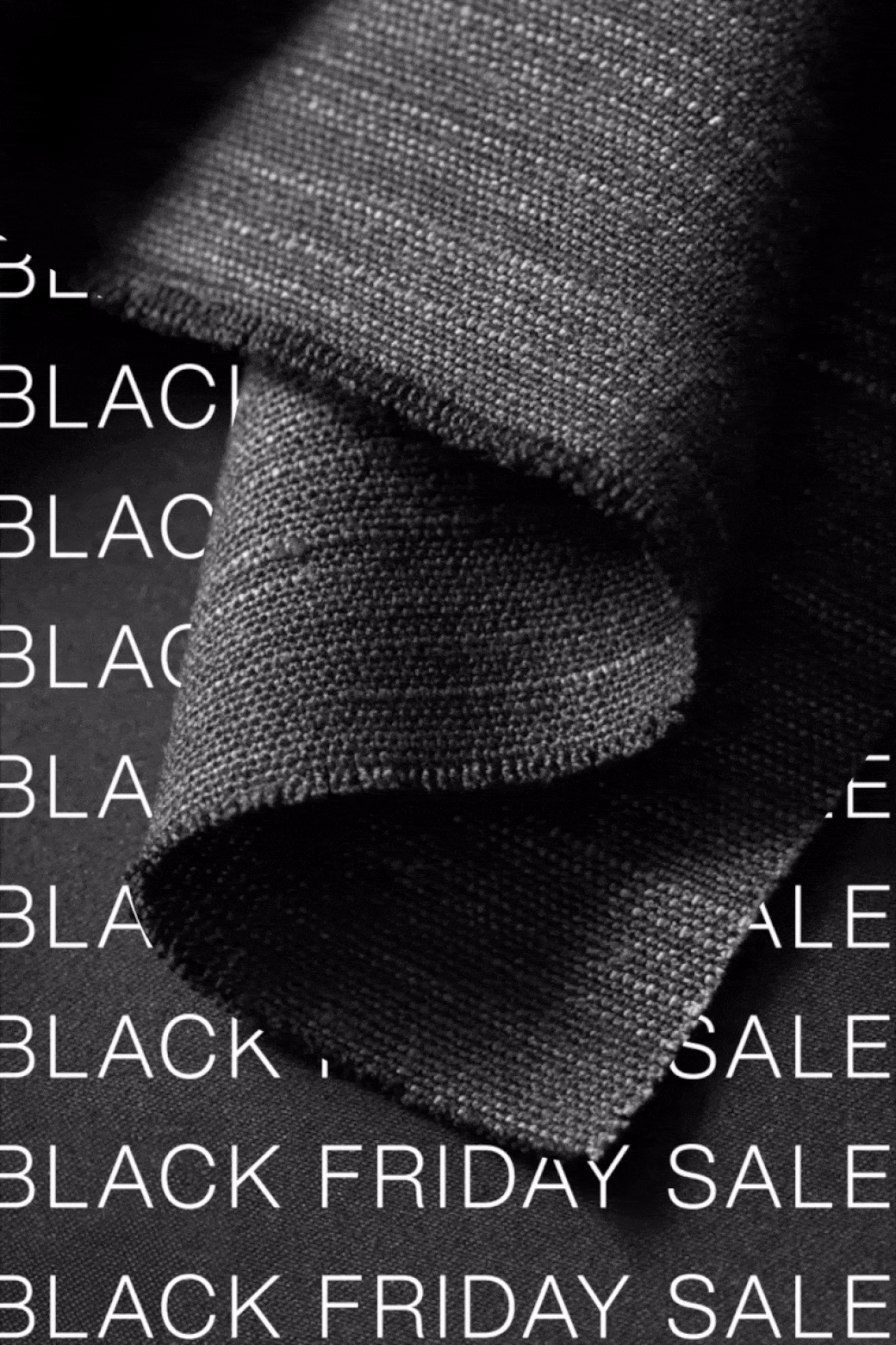 Close-up of folded black fabric with a textured weave, overlaid with white text that reads 'BLACK FRIDAY SALE' repeatedly.