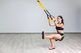 Woman exercising with suspension straps in a gym