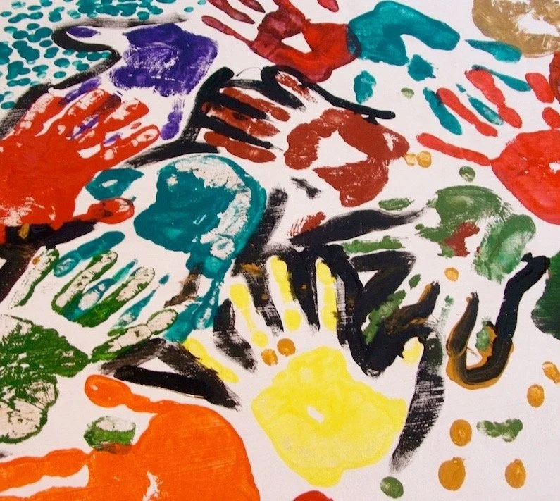 A colorful collection of handprints painted in various colors on a white surface.