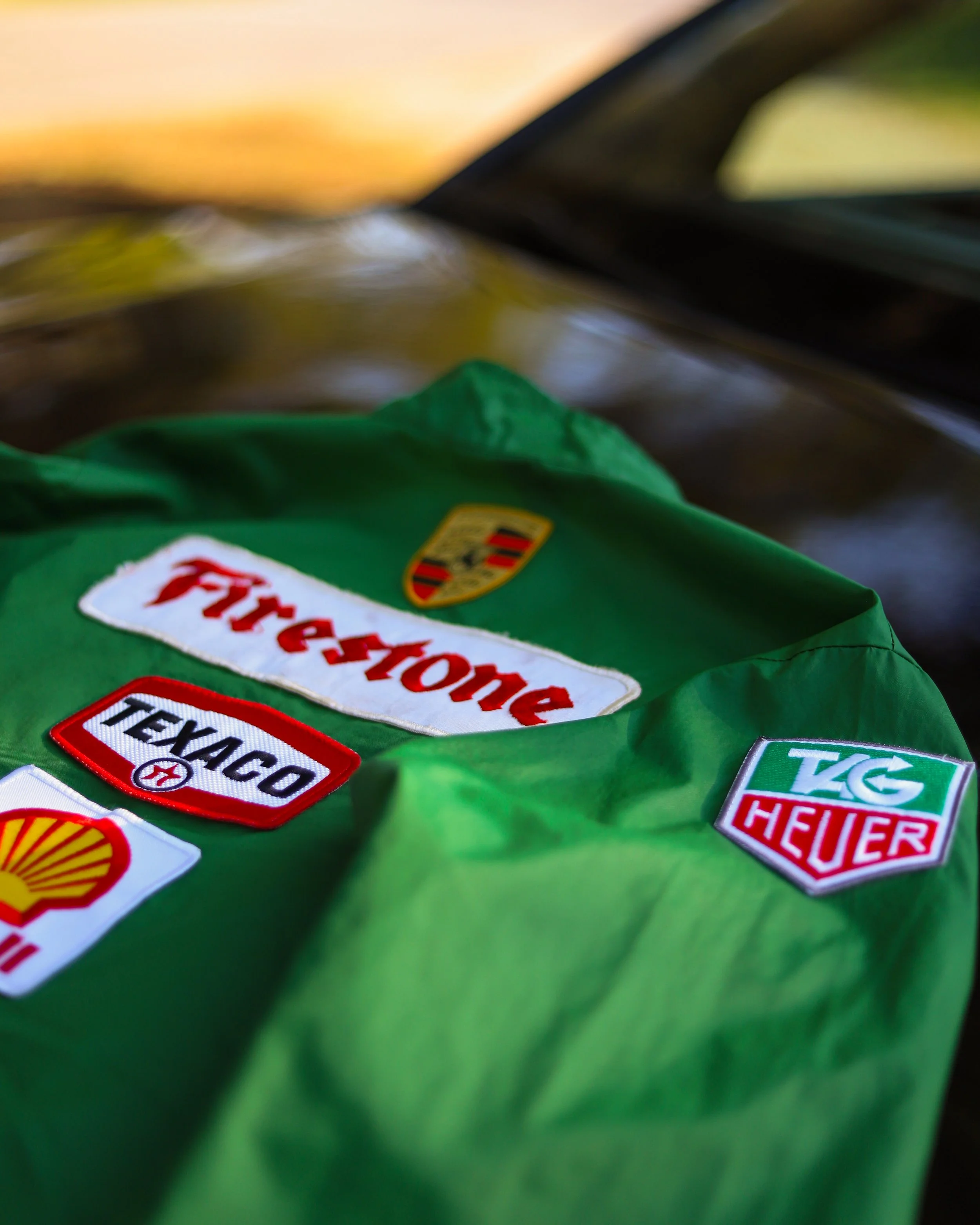 Una giacca verde con patch di sponsorizzazioni, tra cui Ferrari, Shell, Texaco e TAG Heuer.
