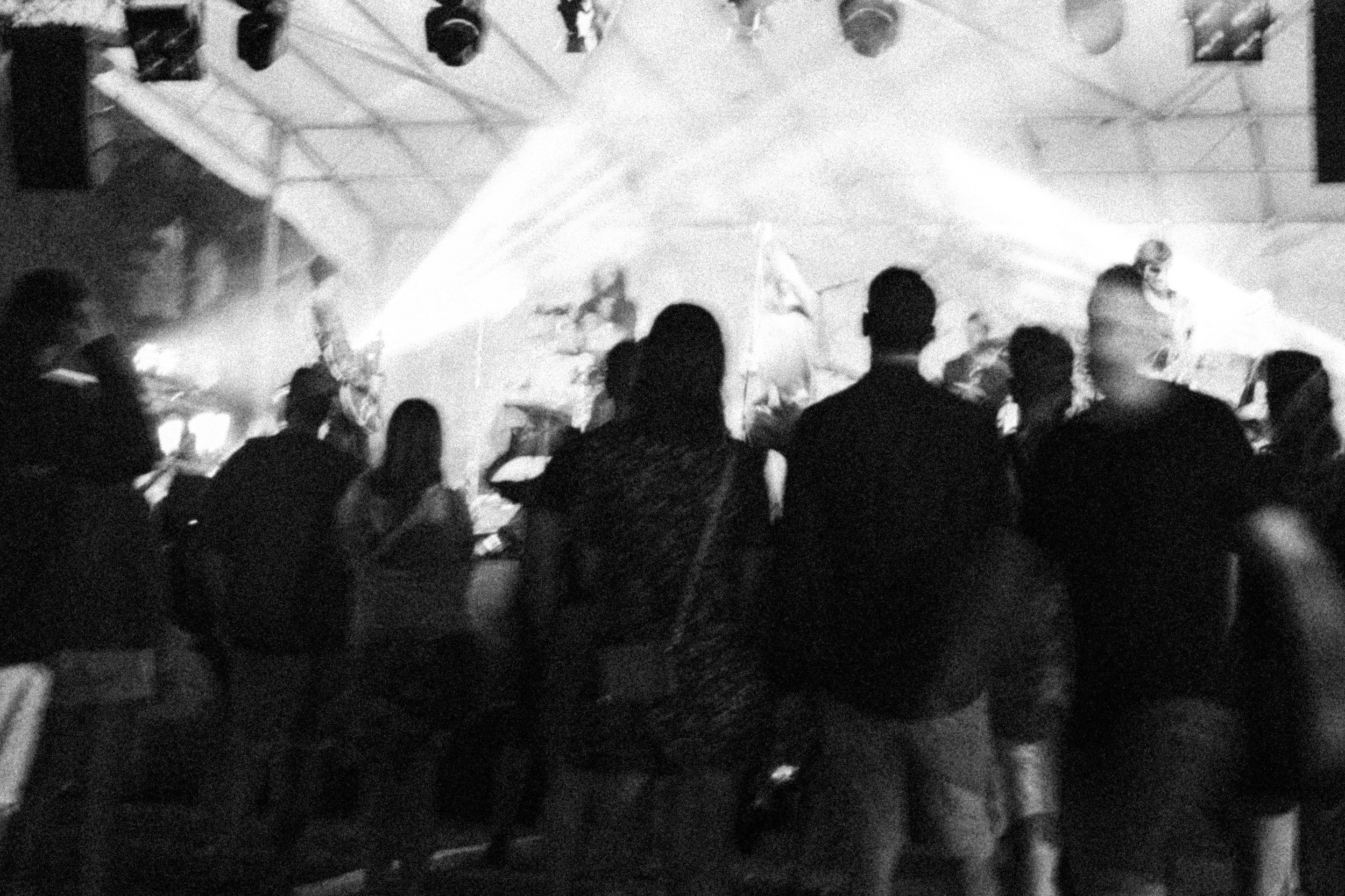 Persone sedute e in piedi davanti a un palco con luci di scena.