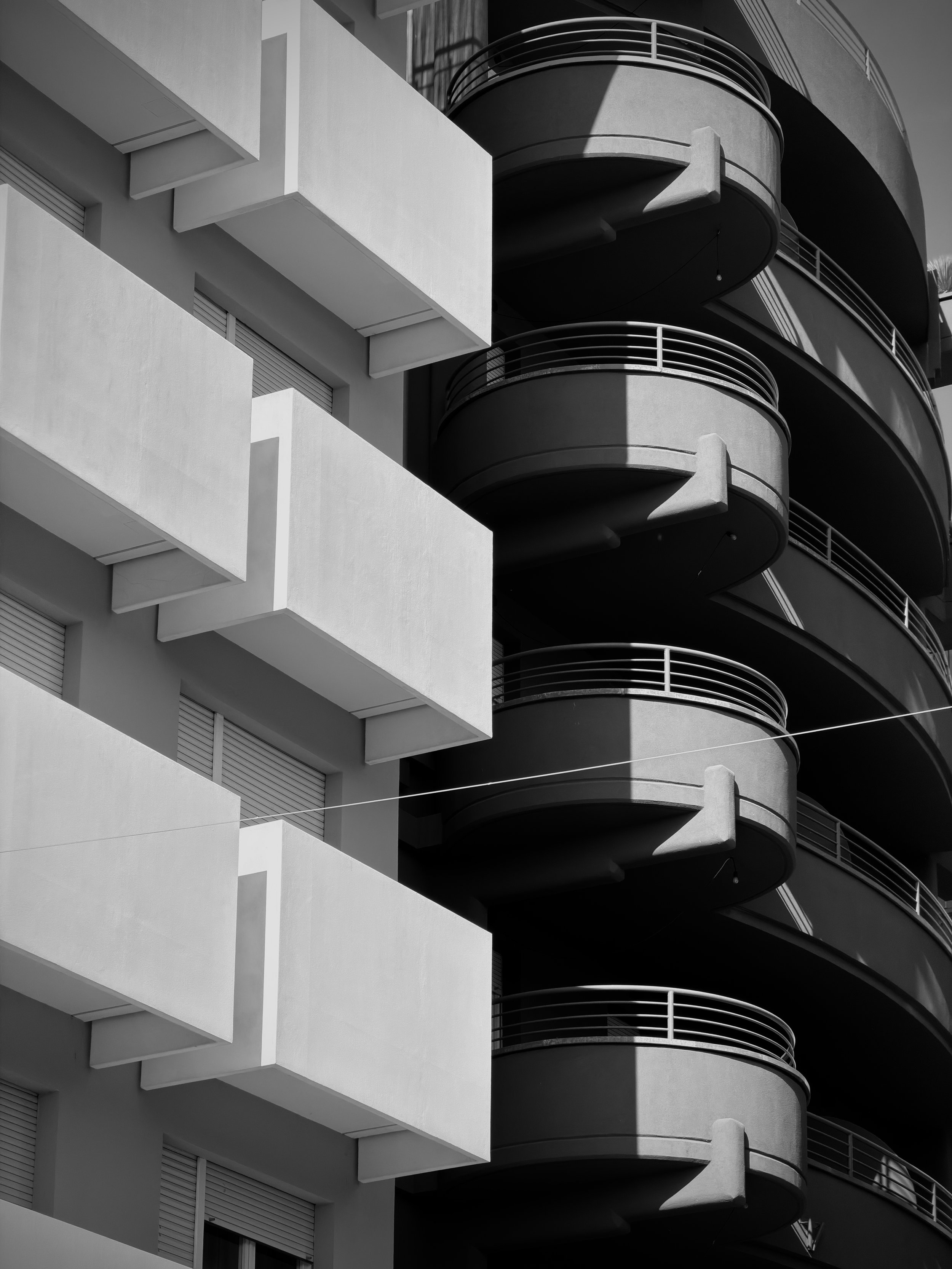 Immagine in bianco e nero di un edificio con balconi curvi e linee moderne.