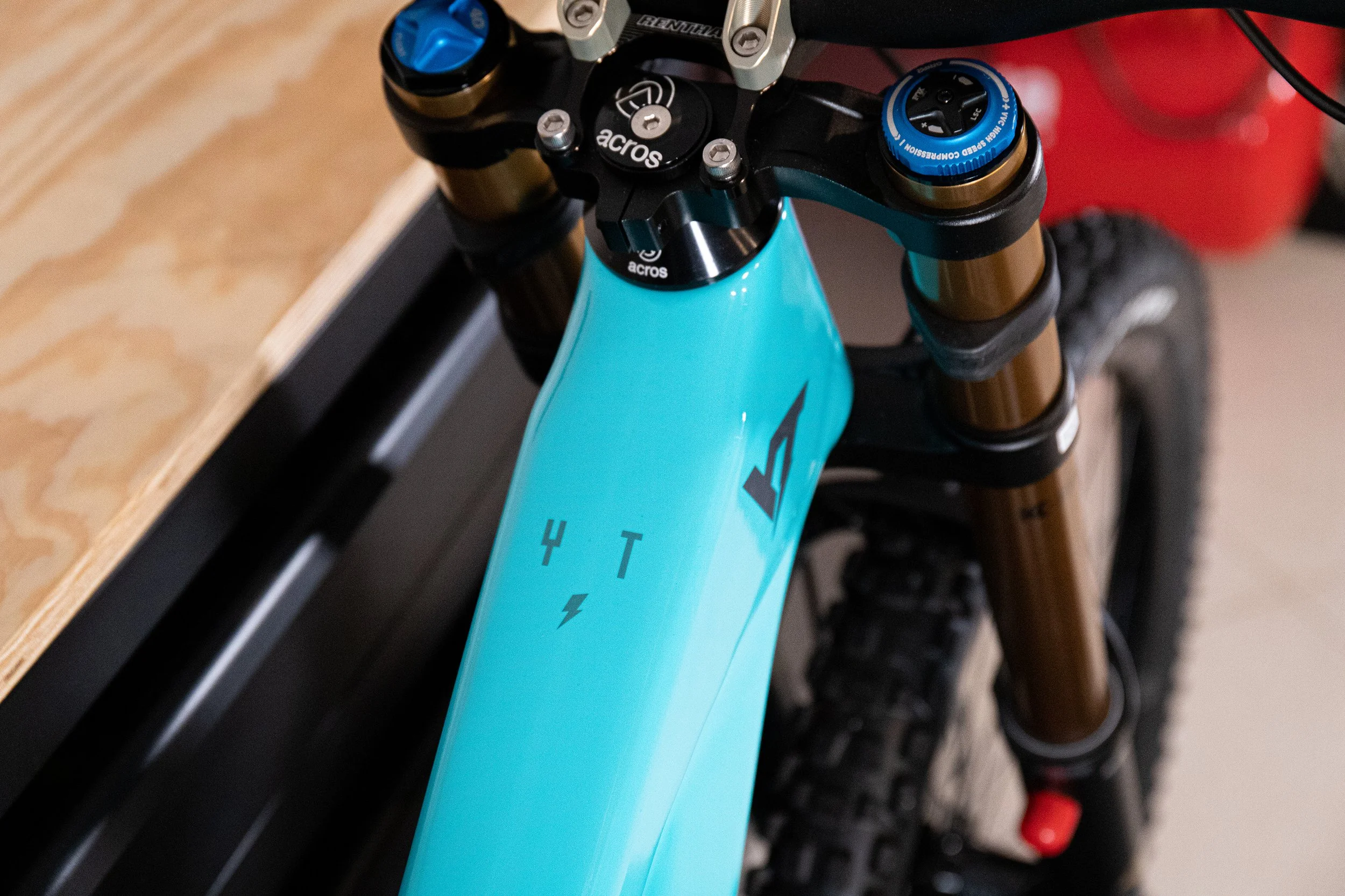 Particolare di una bicicletta da montagna con telaio azzurro, forcella dorata e manubrio