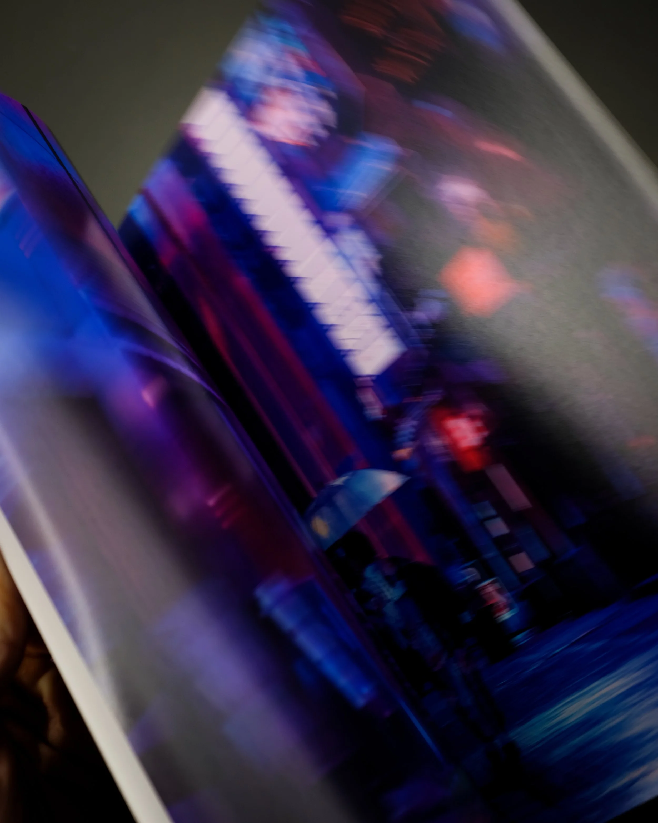 L'immagine mostra uno smartphone con schermata luminosa di colori viola, blu e rosso, leggermente sfocata e in movimento.