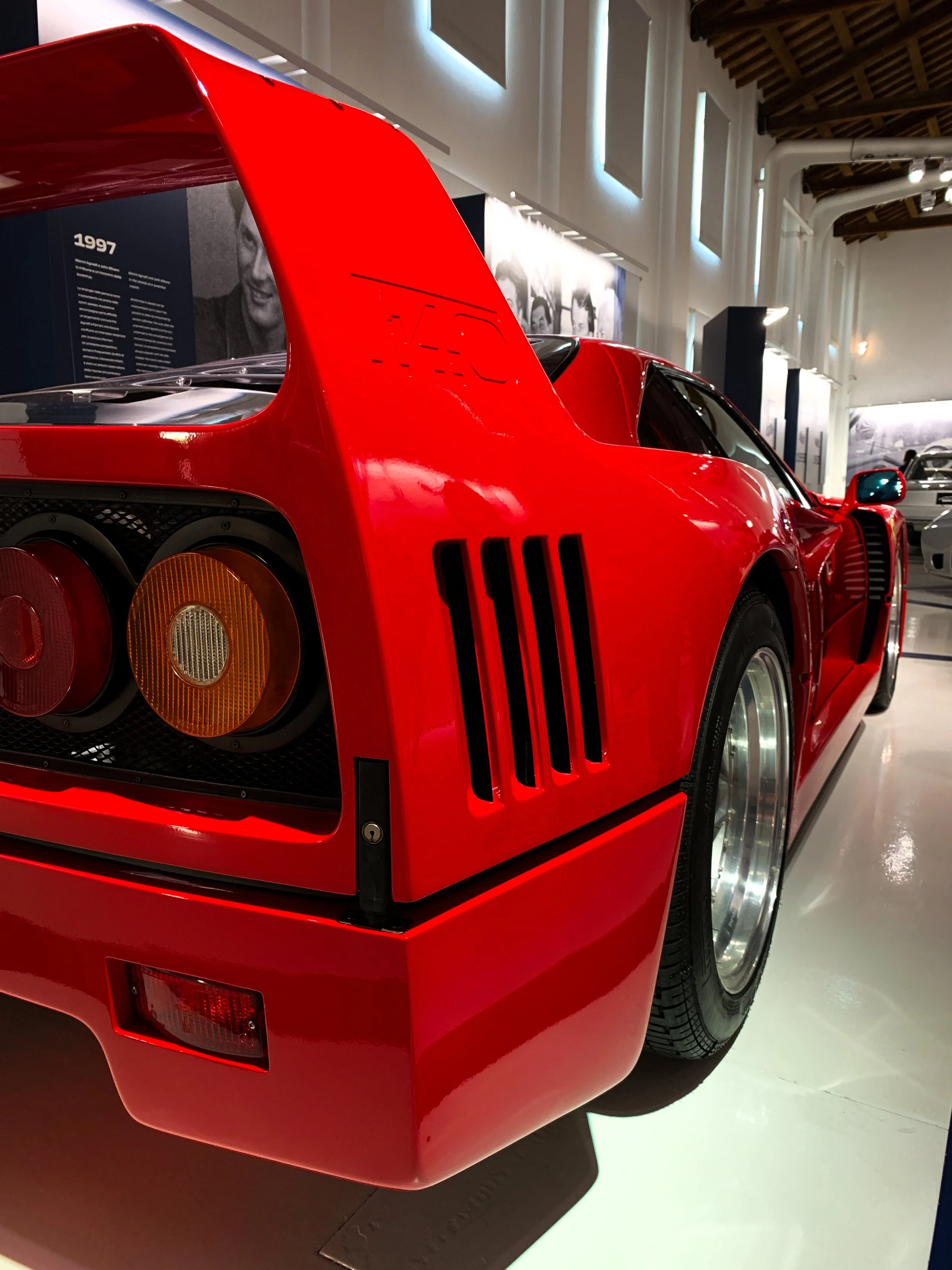 Dettaglio di una Ferrari F40 rossa esposta in un museo, vista dalla mezza parte posteriore