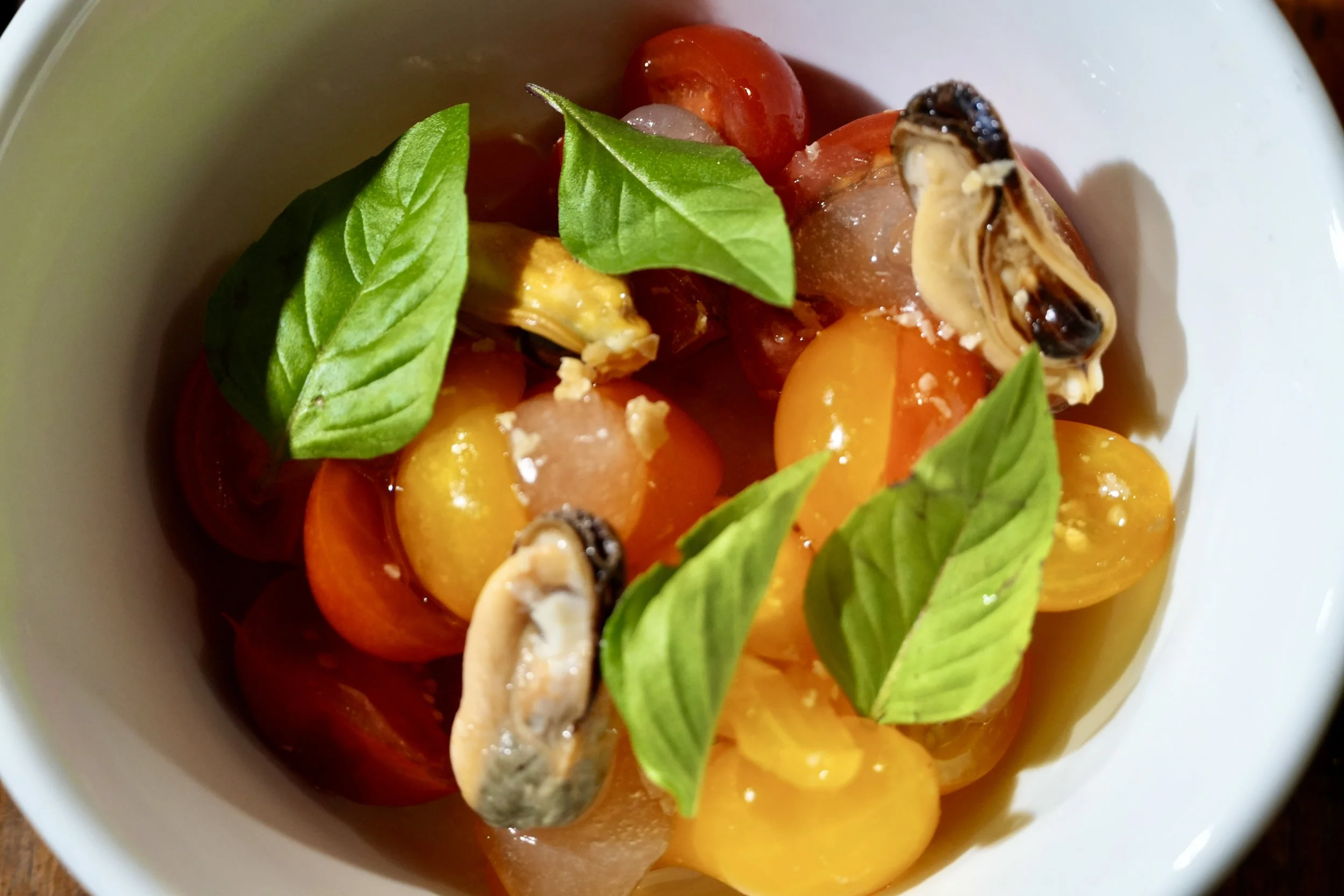 tomatoes dressed with fermented tomato and rose gel, mussels marinated in miso oil, kelp salt, basil 