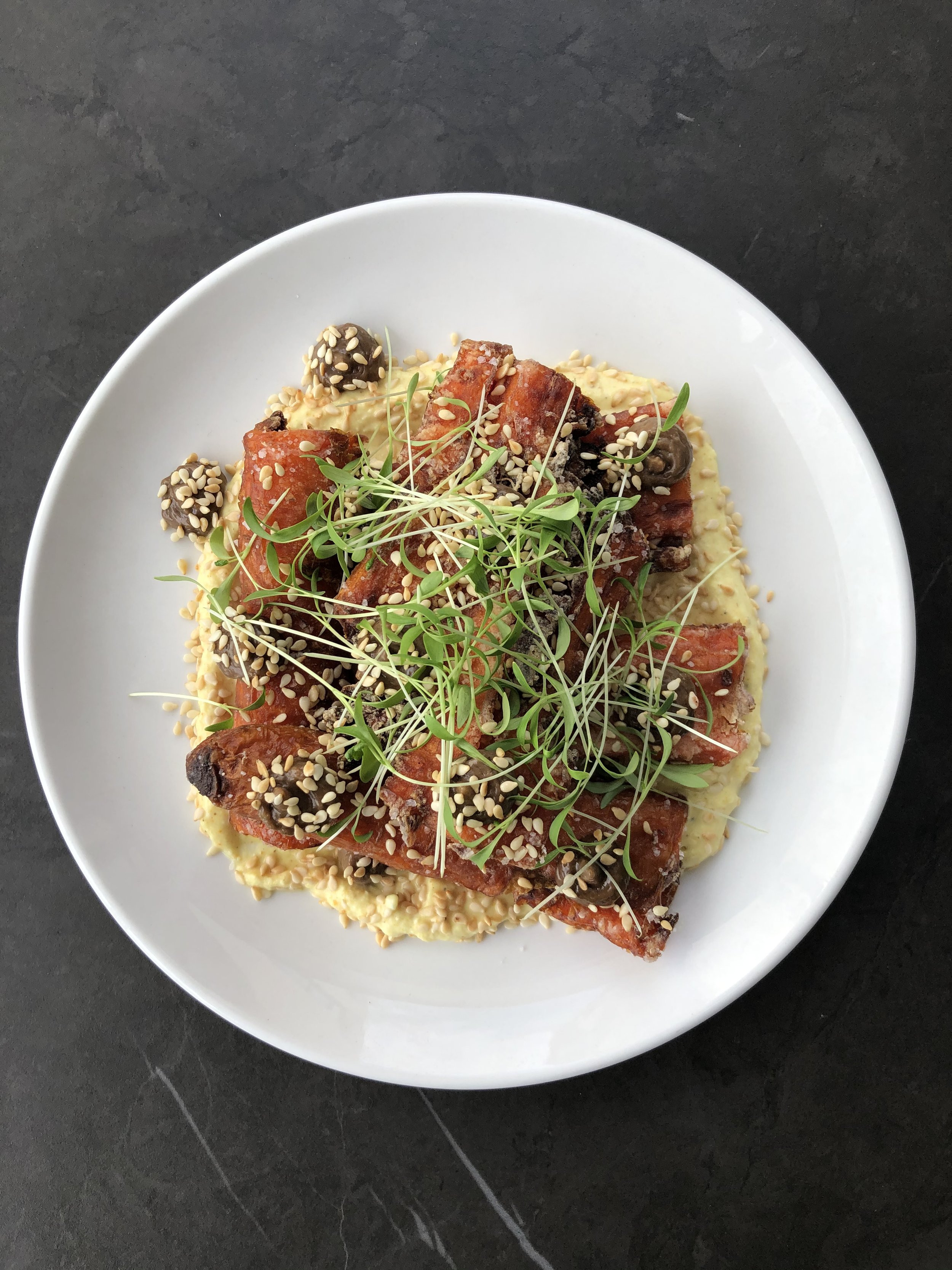 Spring:  Carrot tostones, black garlic emulsion, sesame, cilantro, vadouvan creme fraiche 