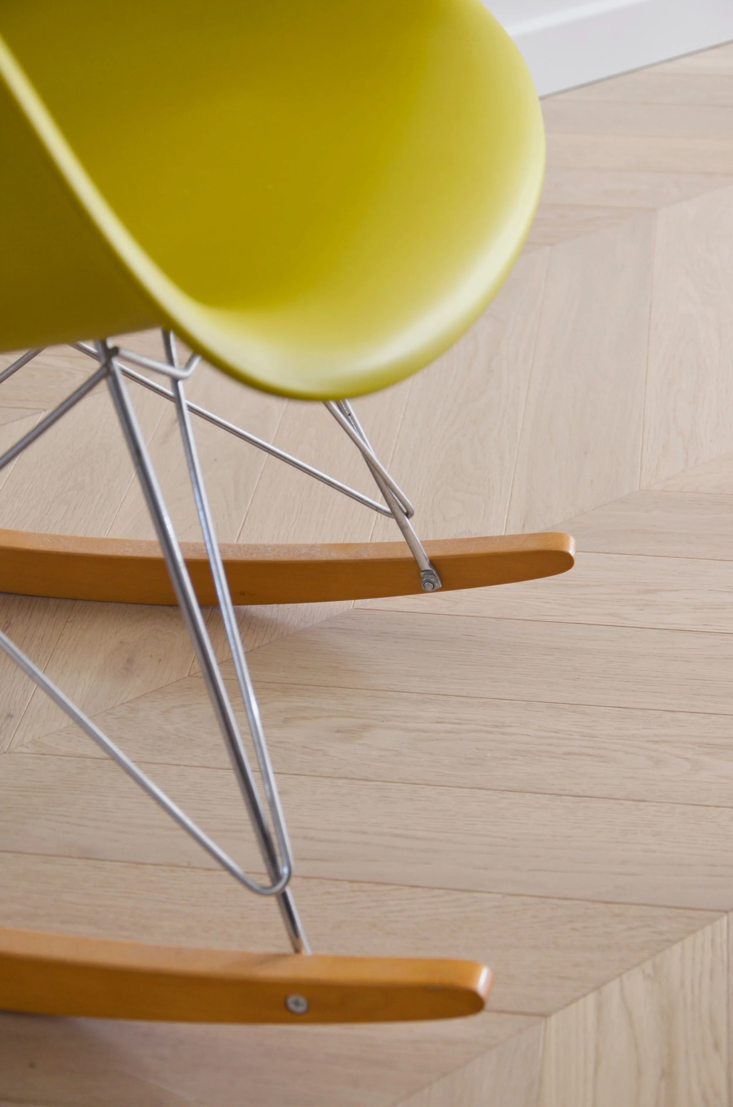 Détail fauteuil Eames sur parquet chevron — salon appartement Marseille, RODES Studio