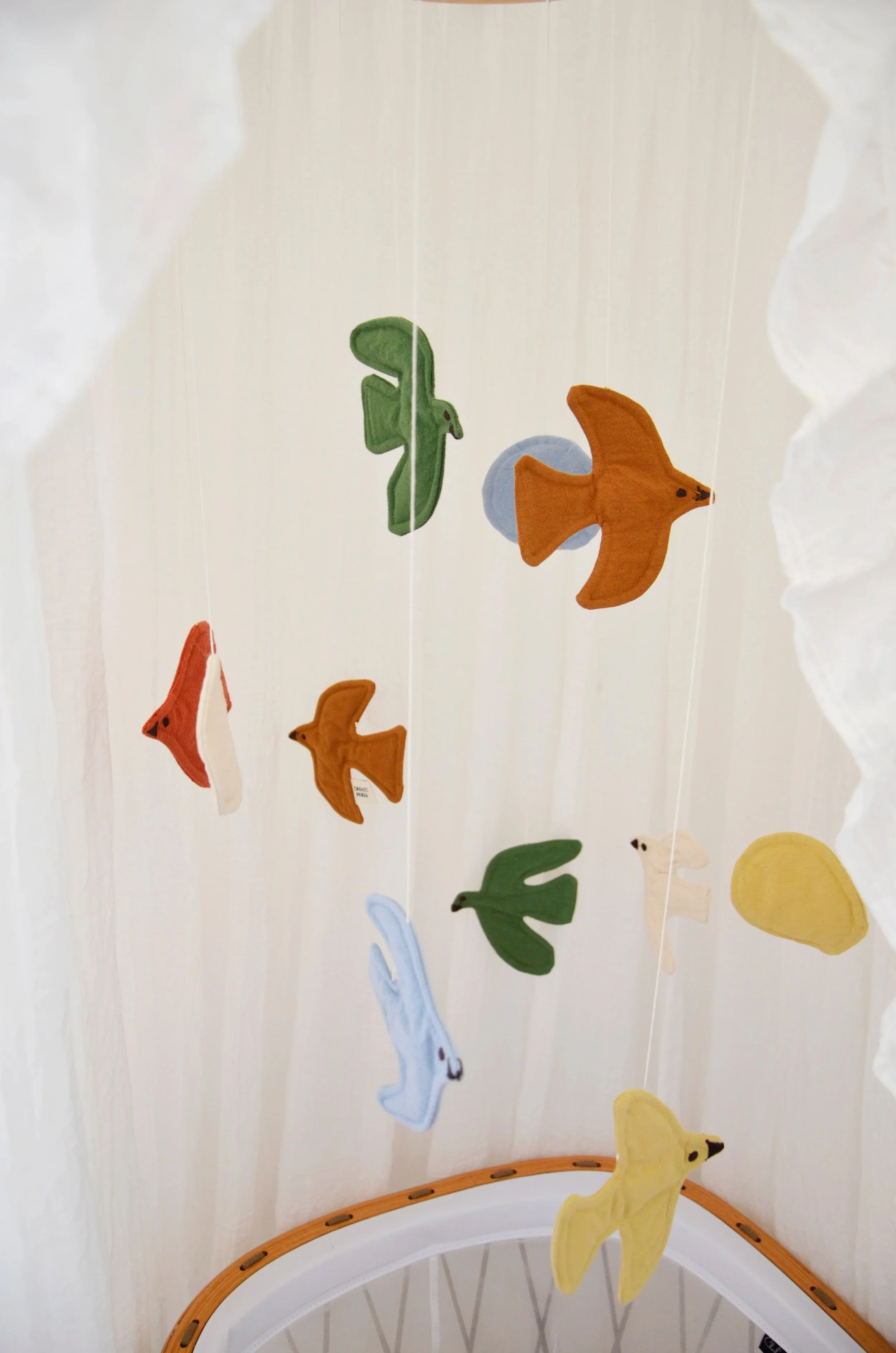 Mobile d'oiseaux en tissu coloré au-dessus du berceau