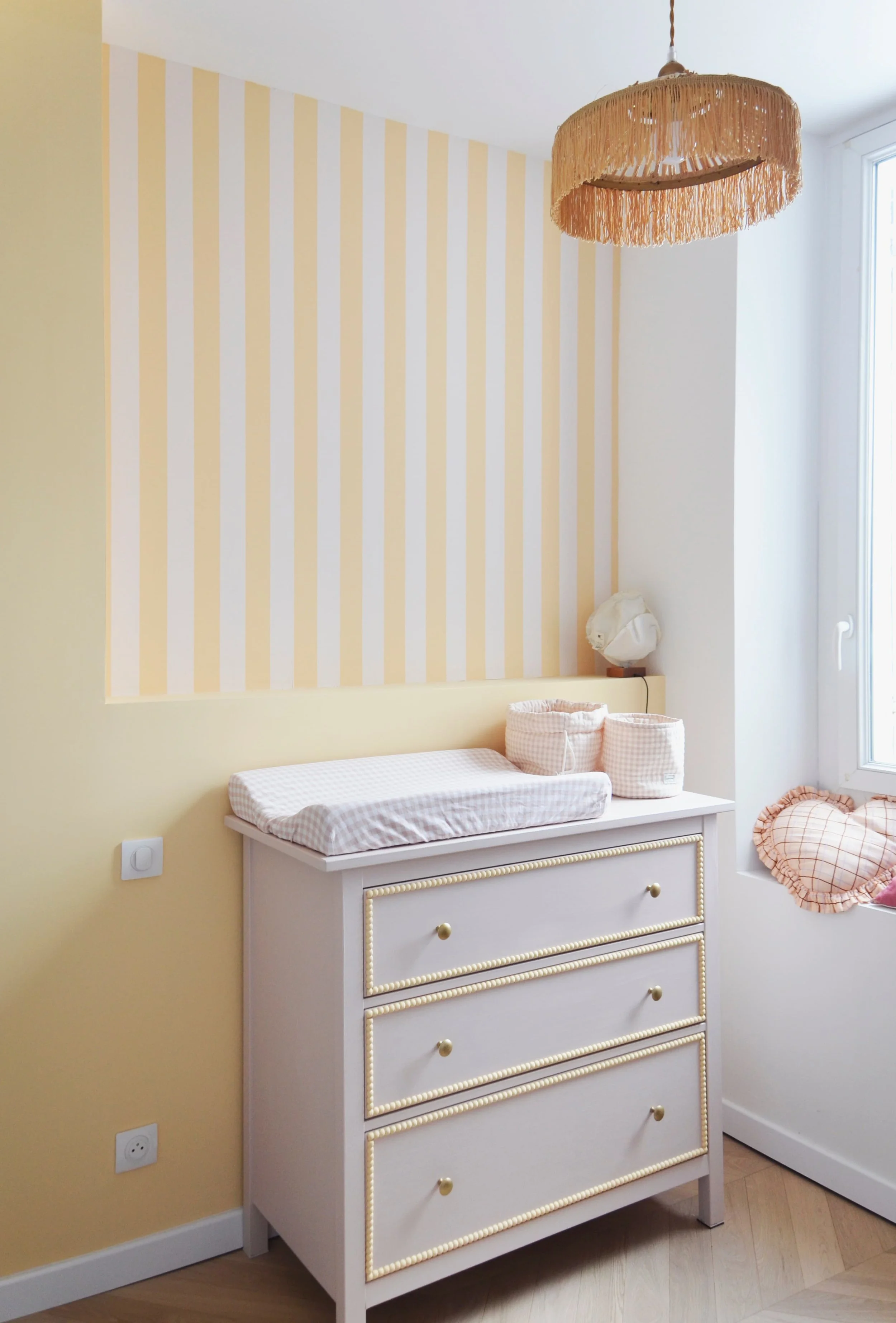 Chambre bébé — commode perlée, mur rayures jaunes et lustre franges dorées, appartement Endoume Marseille, RODES Studio