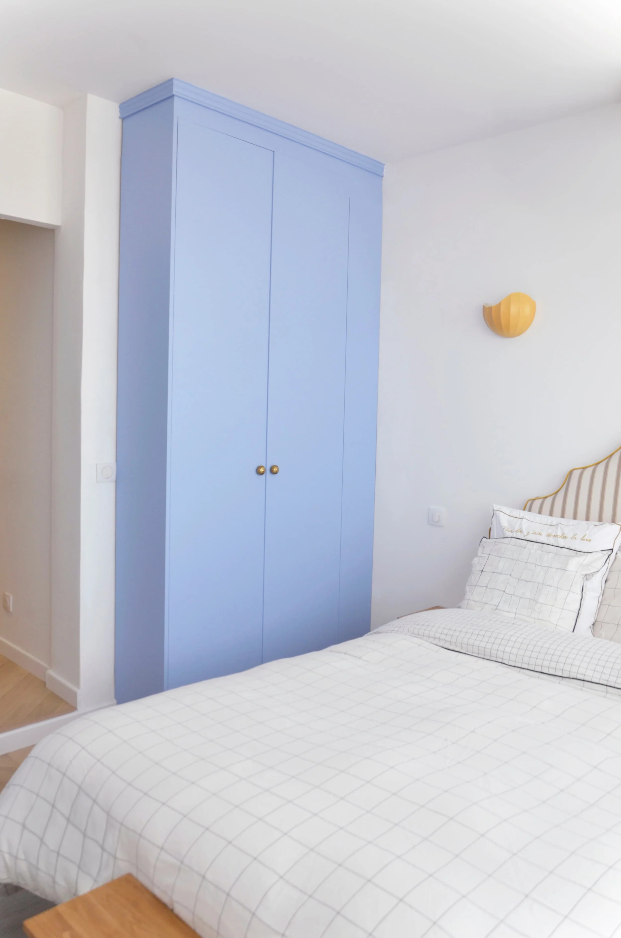 Vue d'ensemble chambre parentale — armoire bleue, applique jaune et tête de lit rayée, Marseille, RODES Studio