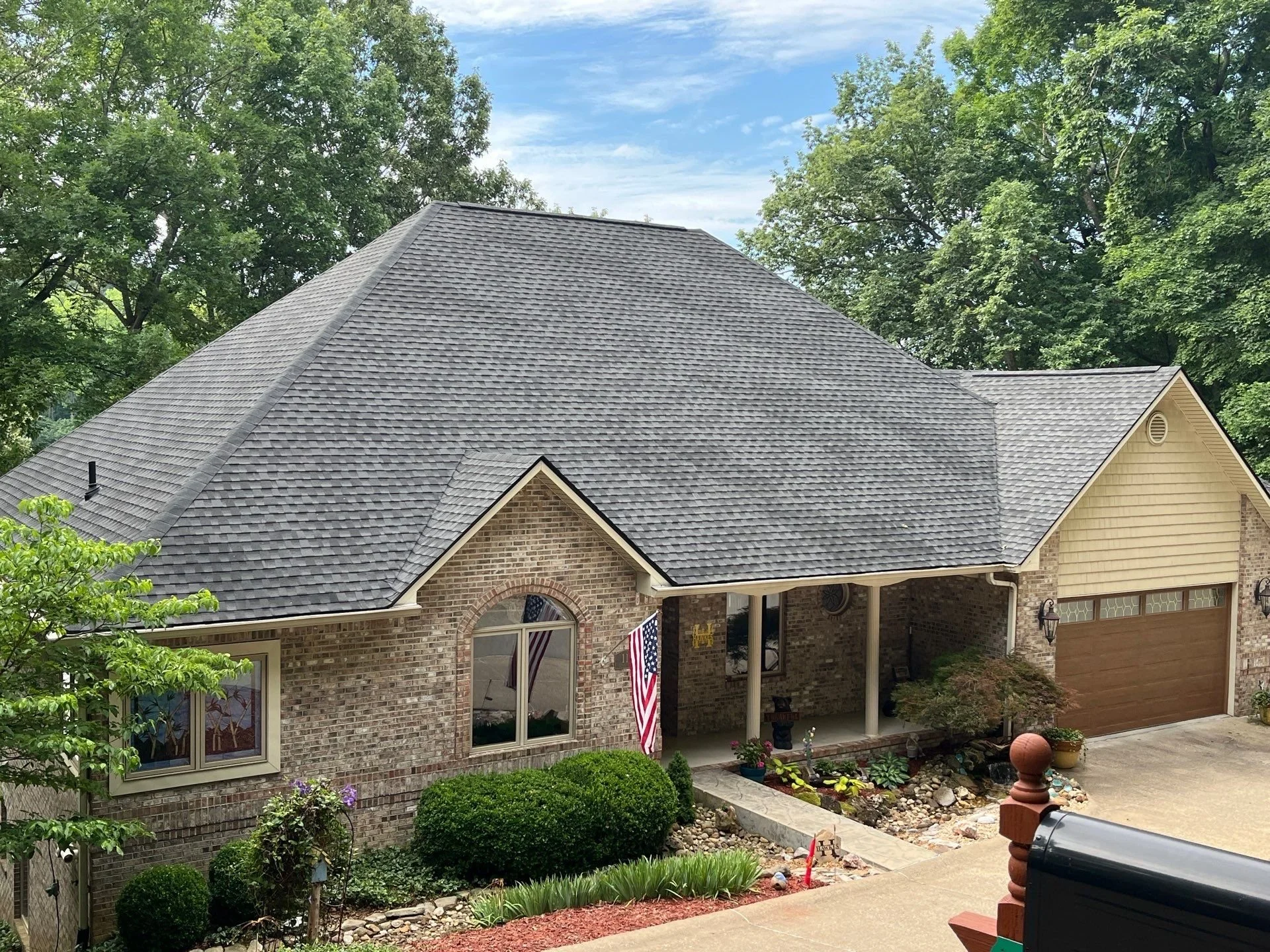 Completed roof replacement on a brick home in Kentucky with gray architectural shingles.