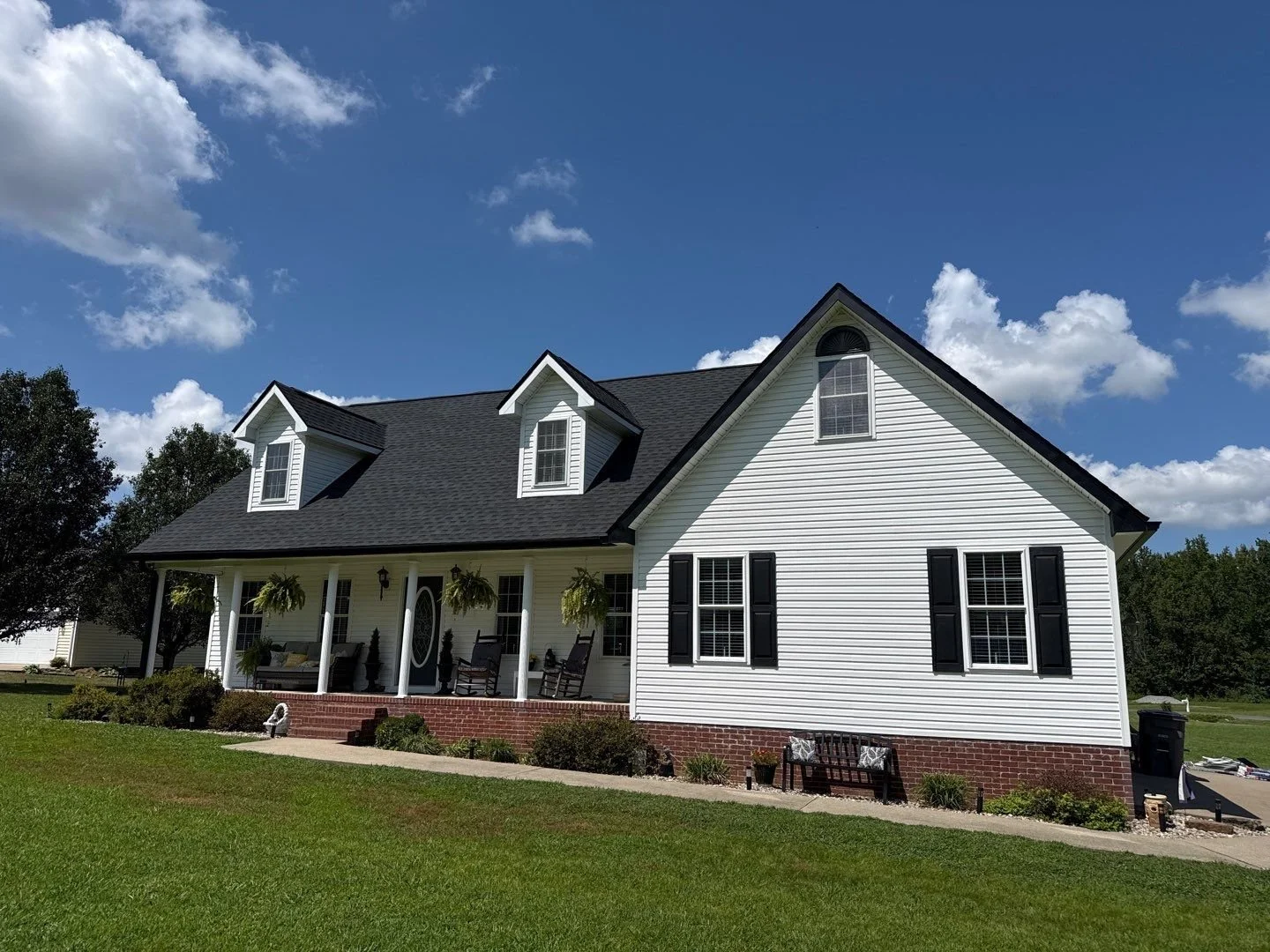 Completed roof replacement on a white two-story home in Clarkson, Kentucky with black architectural shingles.