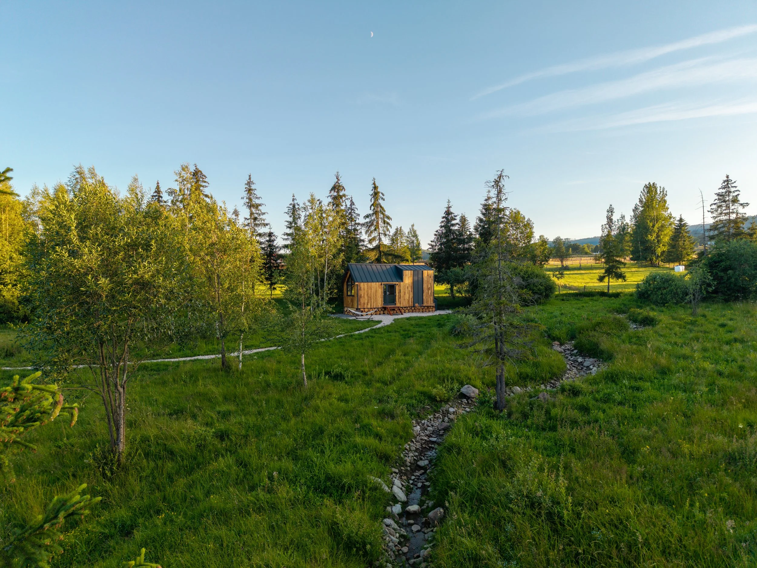 aerial view of WildKind Green Tiny House near a brook in Tara Dornelor Romania