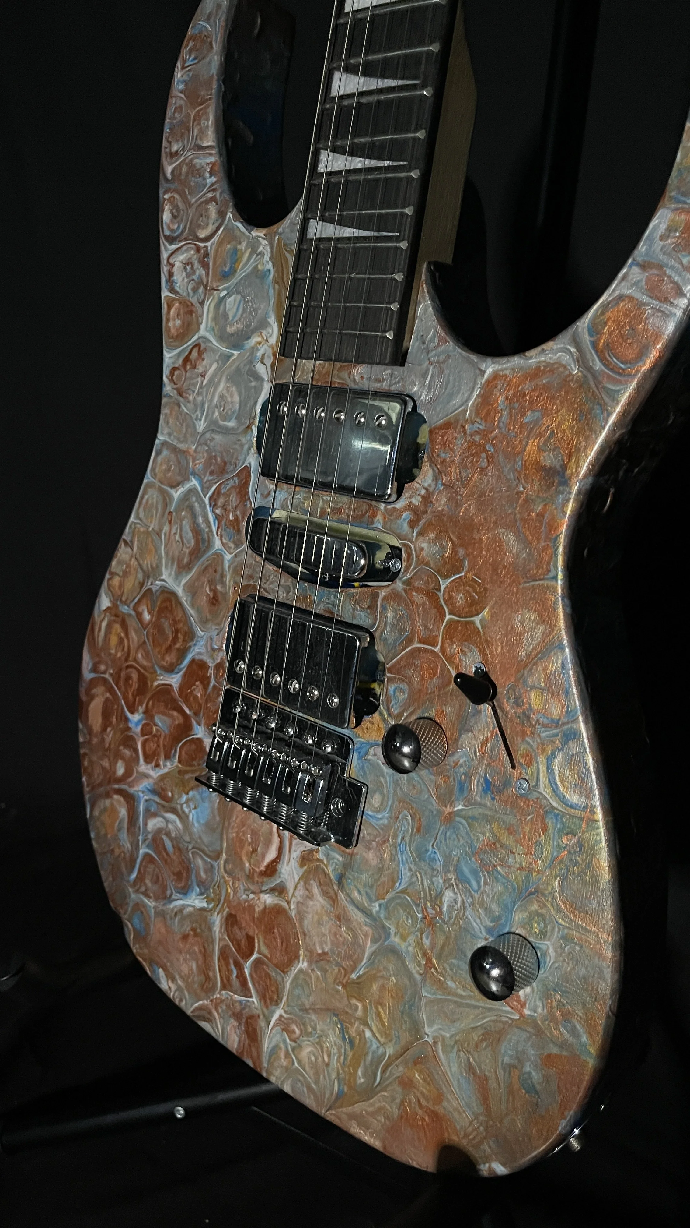 A bronze, gold, silver and blue acrylic poured electric guitar named Tutankhamen by Grainrot Guitars