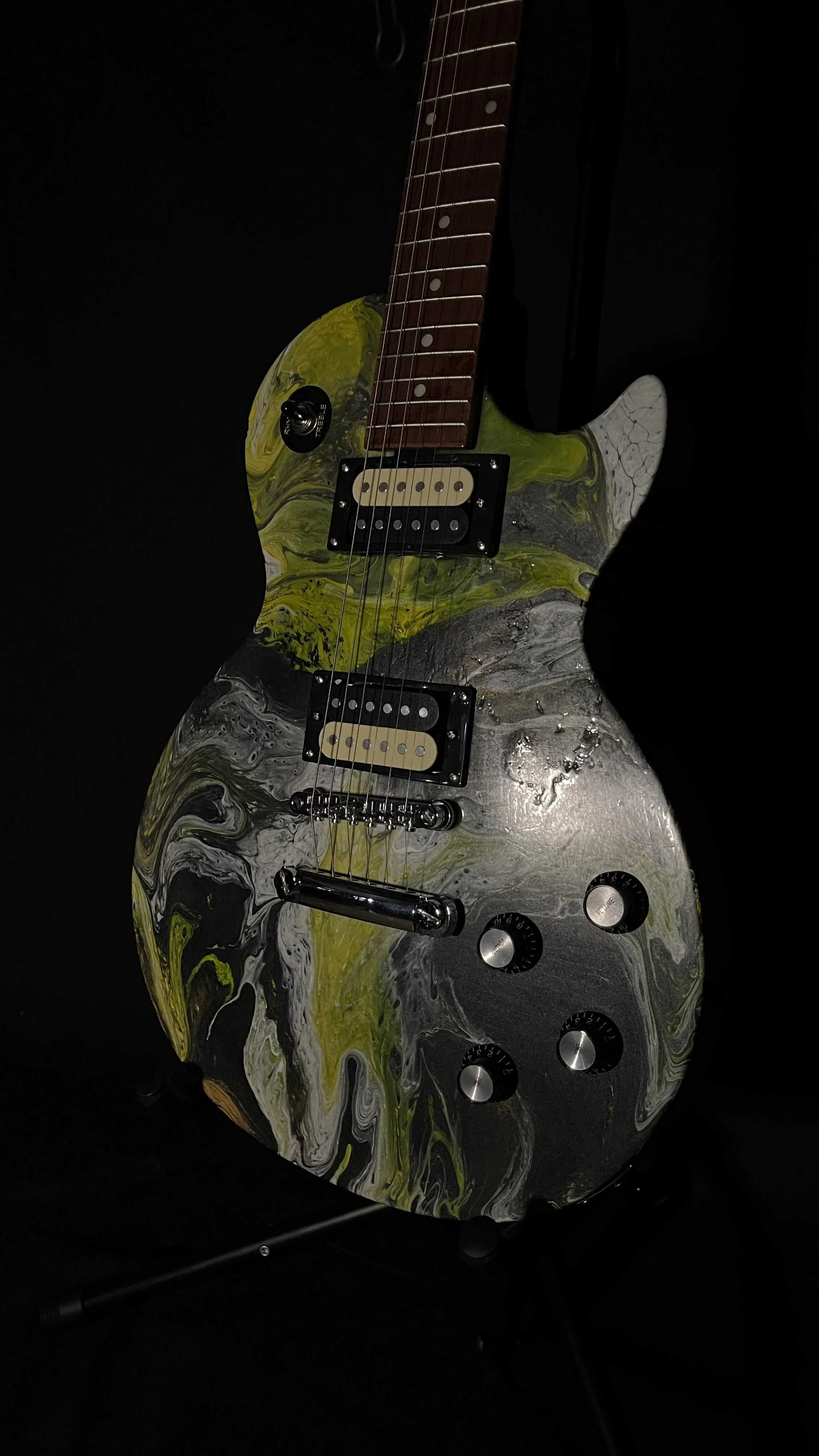 A yellow, white and black acrylic poured electric guitar named Prometheus by Grainrot Guitars