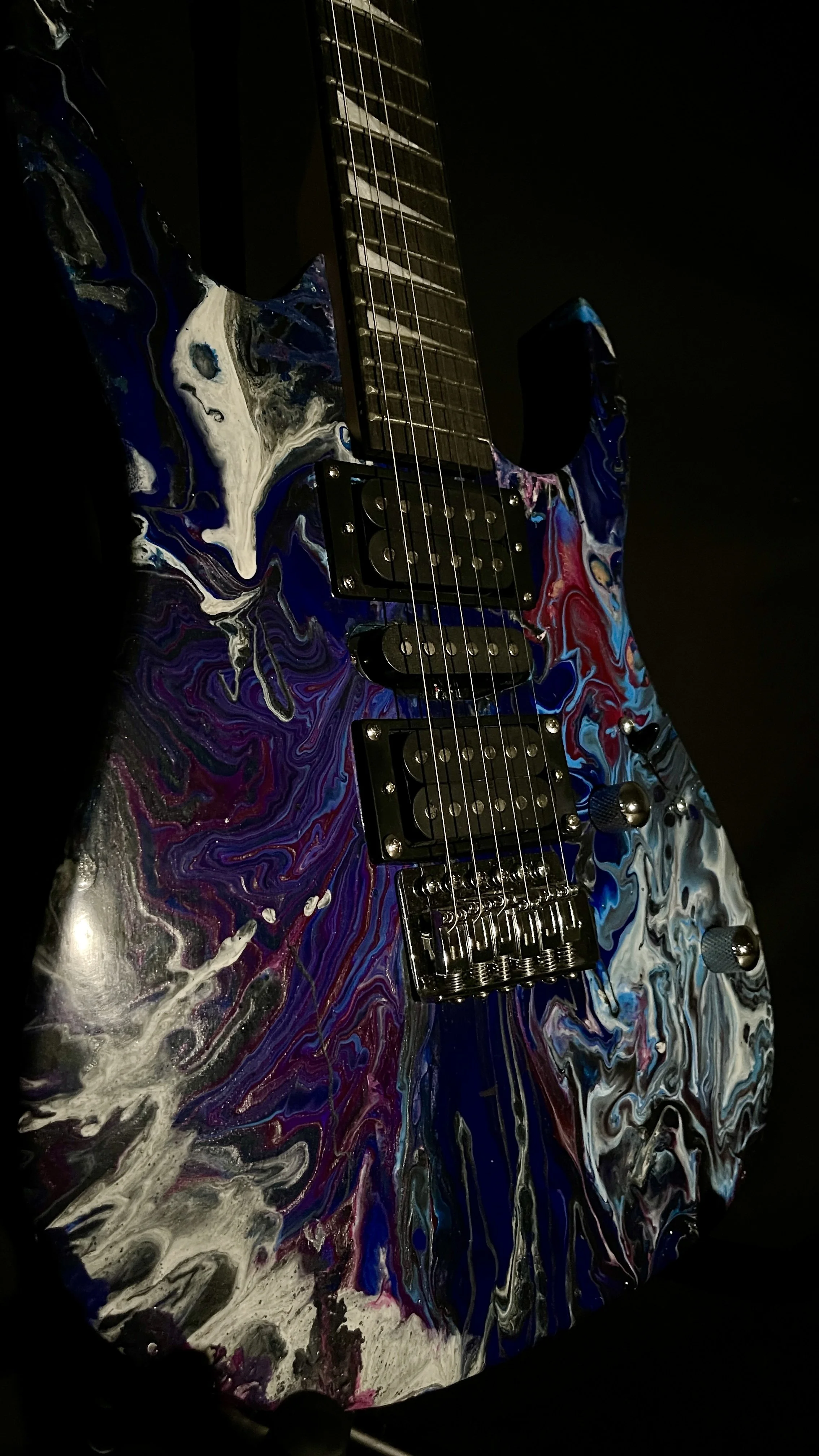 A black, white, blue and purple acrylic poured electric guitar named Nyx by Grainrot Guitars