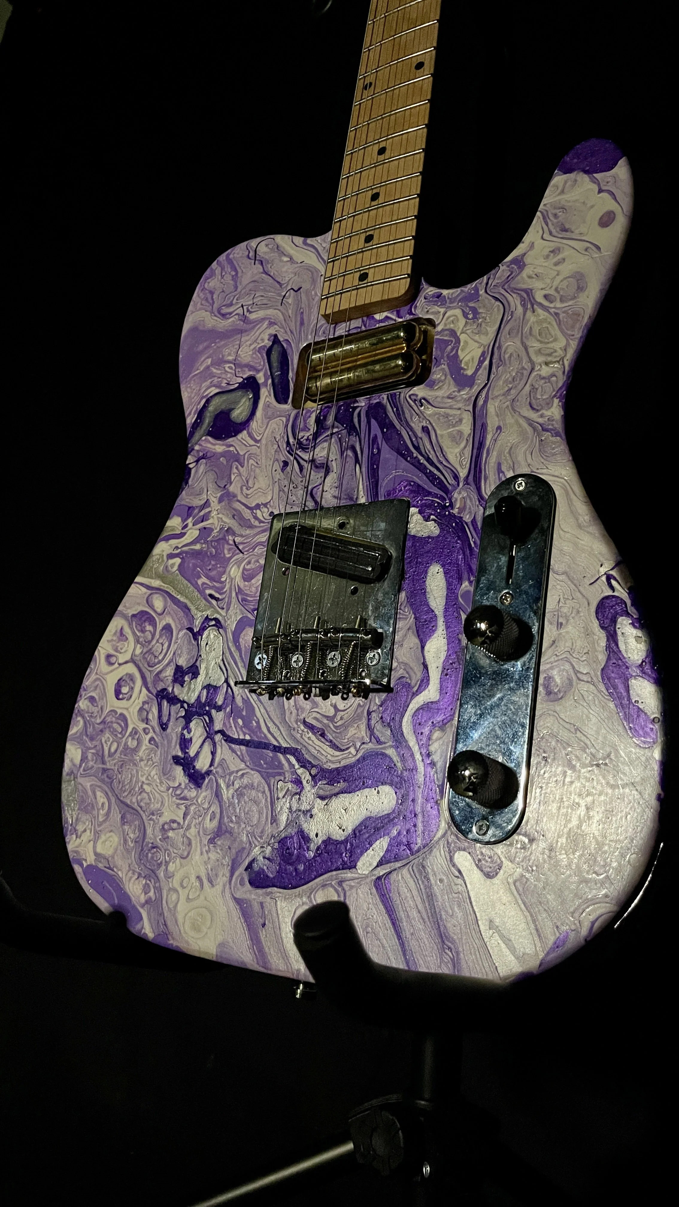 An acrylic poured electric guitar in a wide array of purples and whites. Named Ankhesenamun by Grainrot Guitars.