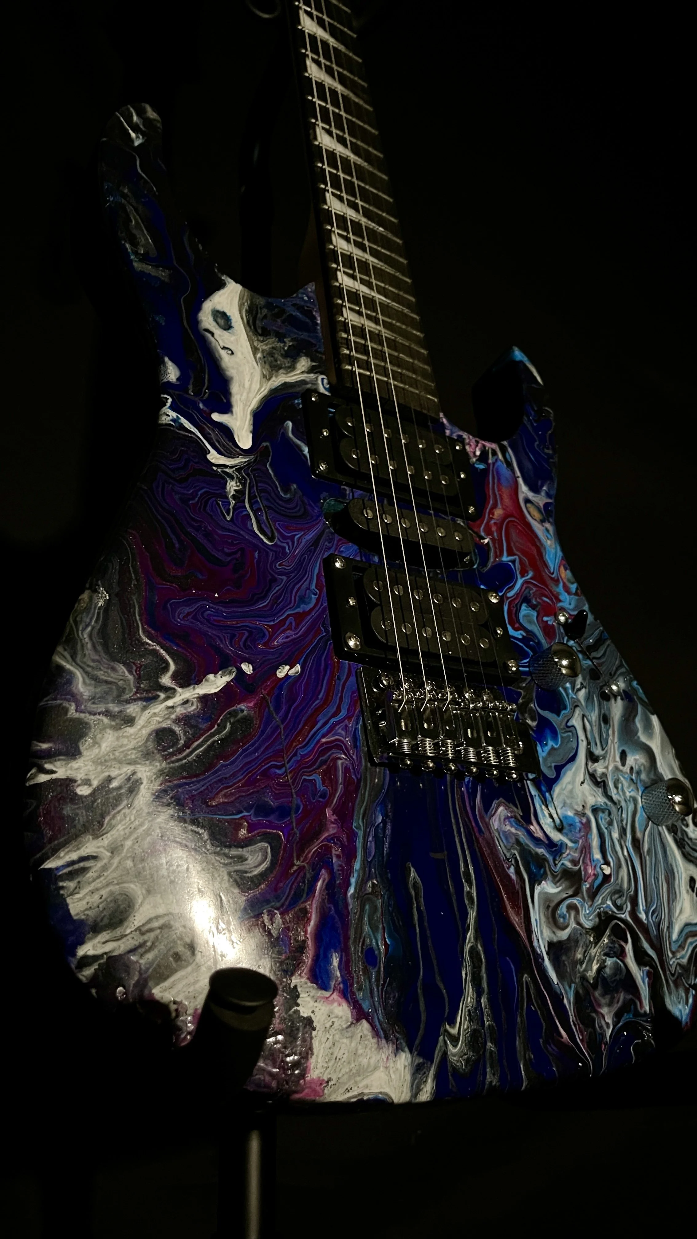 A black, white, blue and purple acrylic poured electric guitar named Nyx by Grainrot Guitars