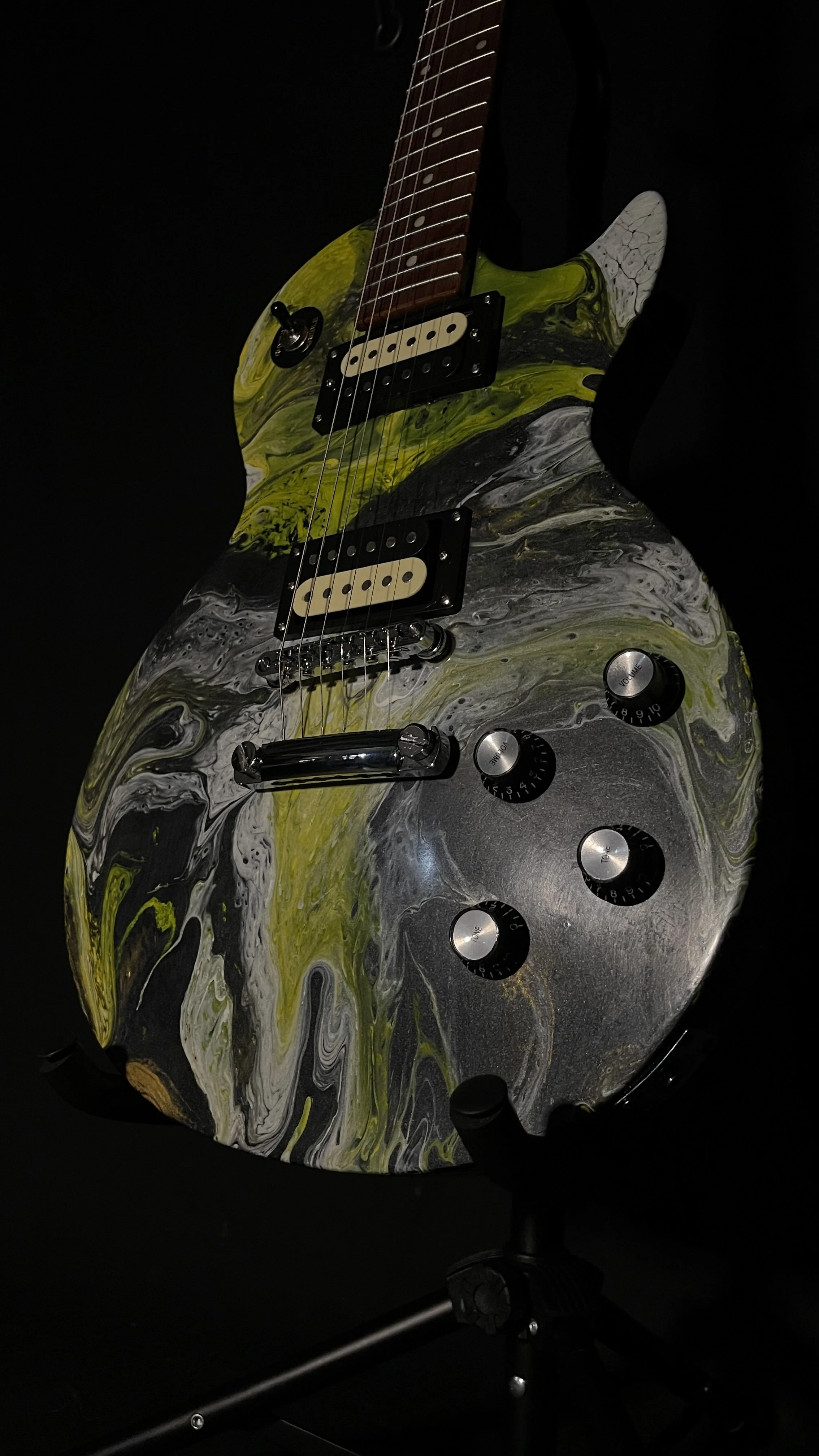 A yellow, white and black acrylic poured electric guitar named Prometheus by Grainrot Guitars