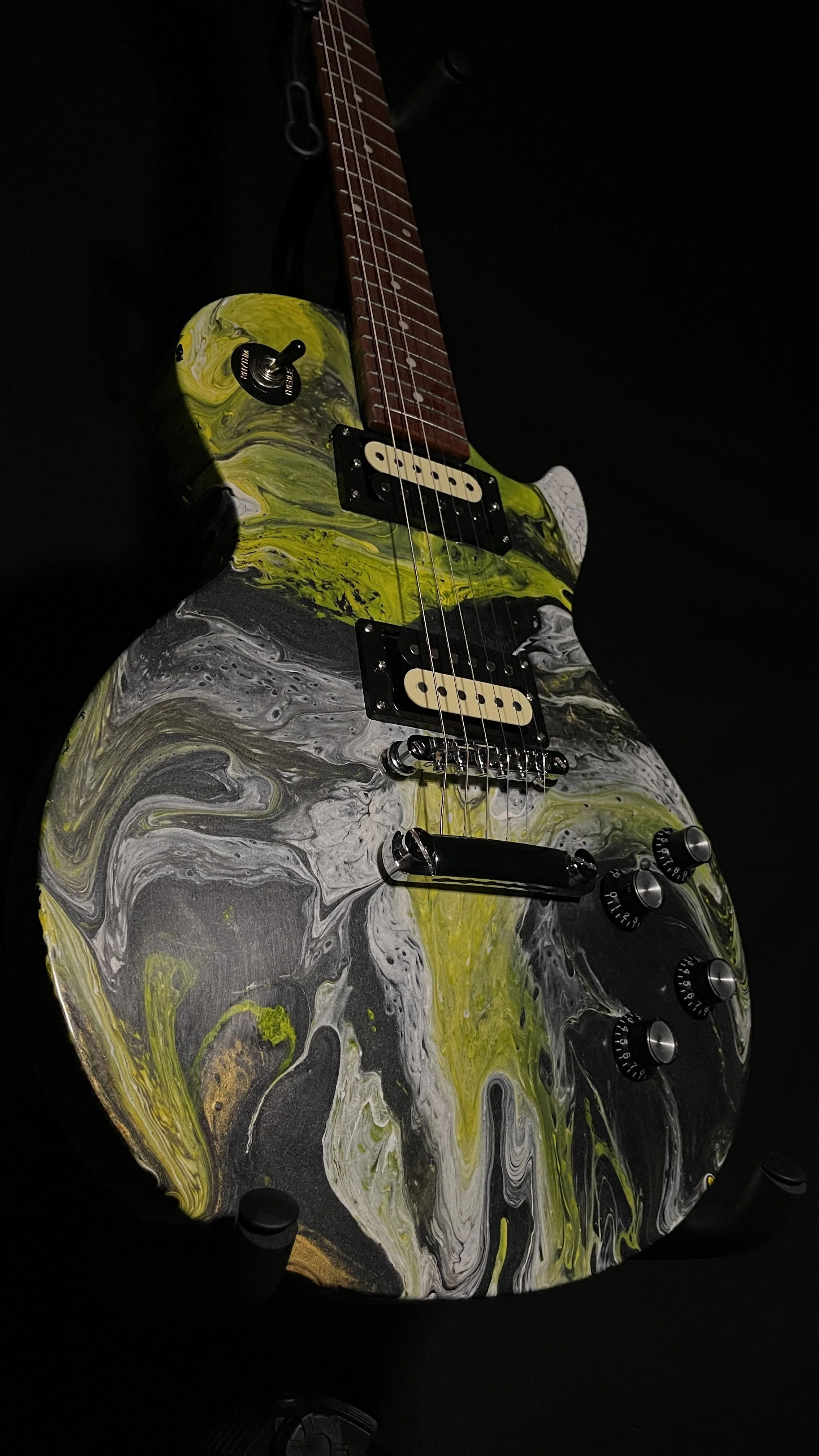 A yellow, white and black acrylic poured electric guitar named Prometheus by Grainrot Guitars