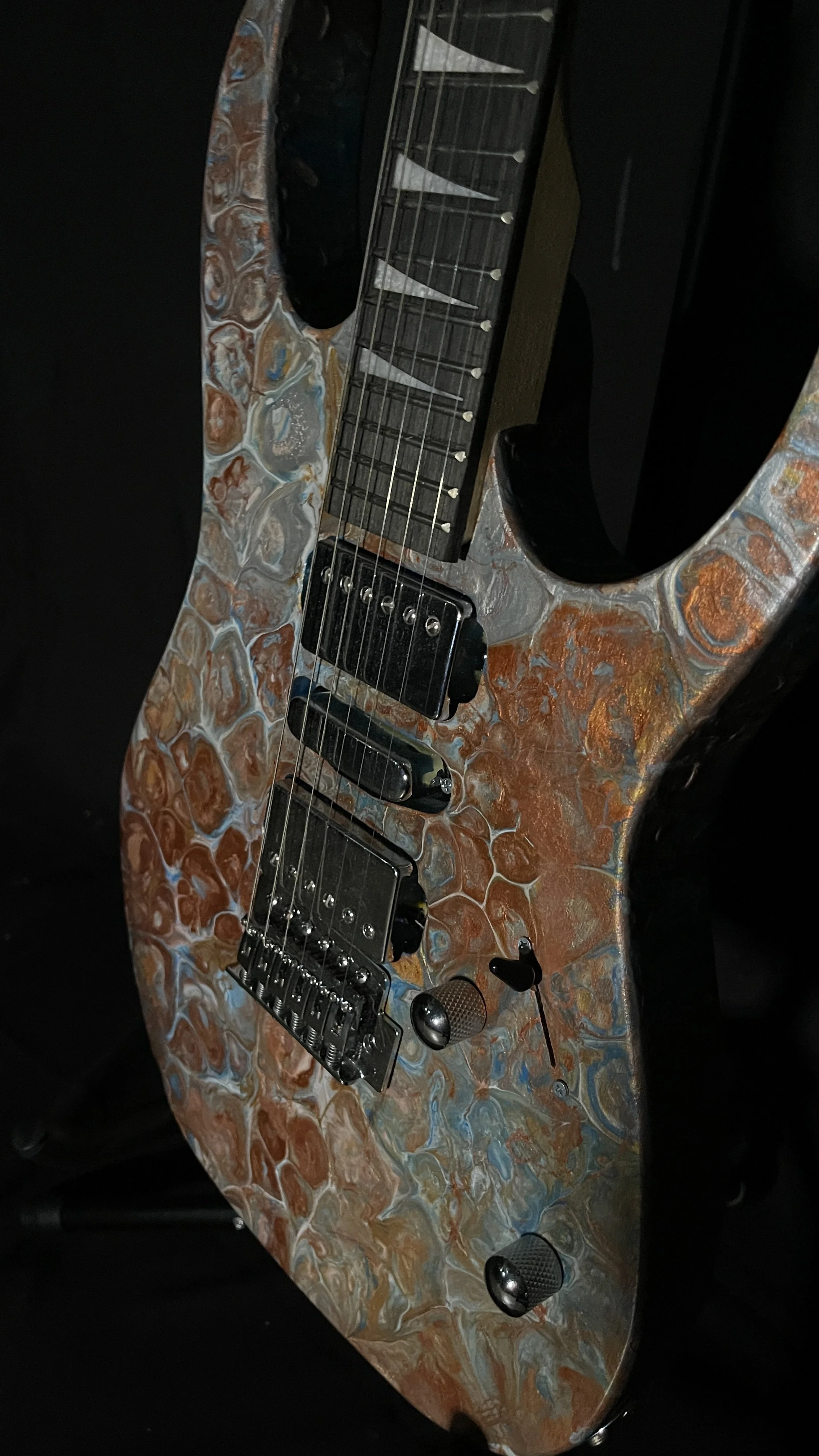 A bronze, gold, silver and blue acrylic poured electric guitar named Tutankhamen by Grainrot Guitars