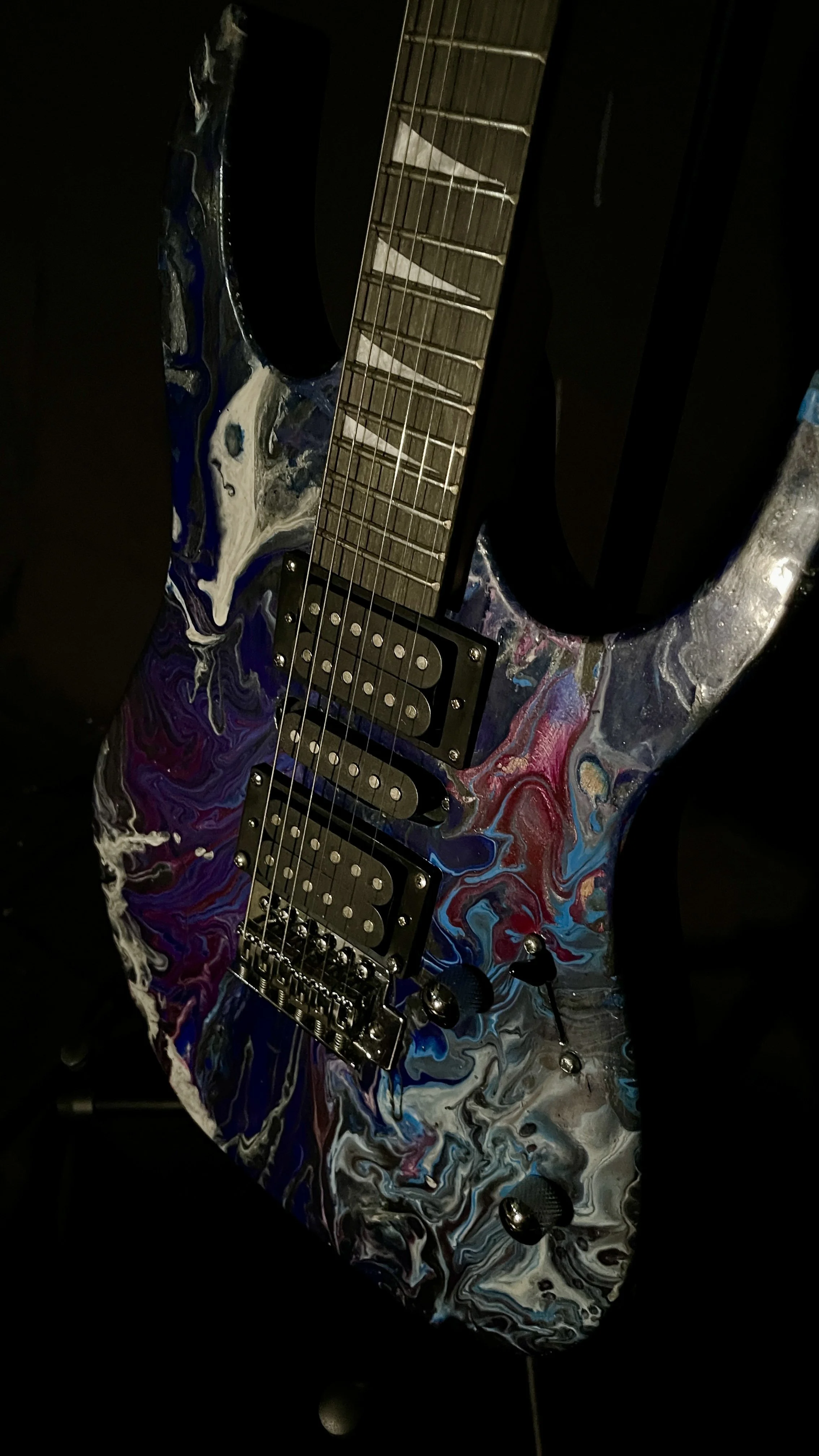 A black, white, blue and purple acrylic poured electric guitar named Nyx by Grainrot Guitars