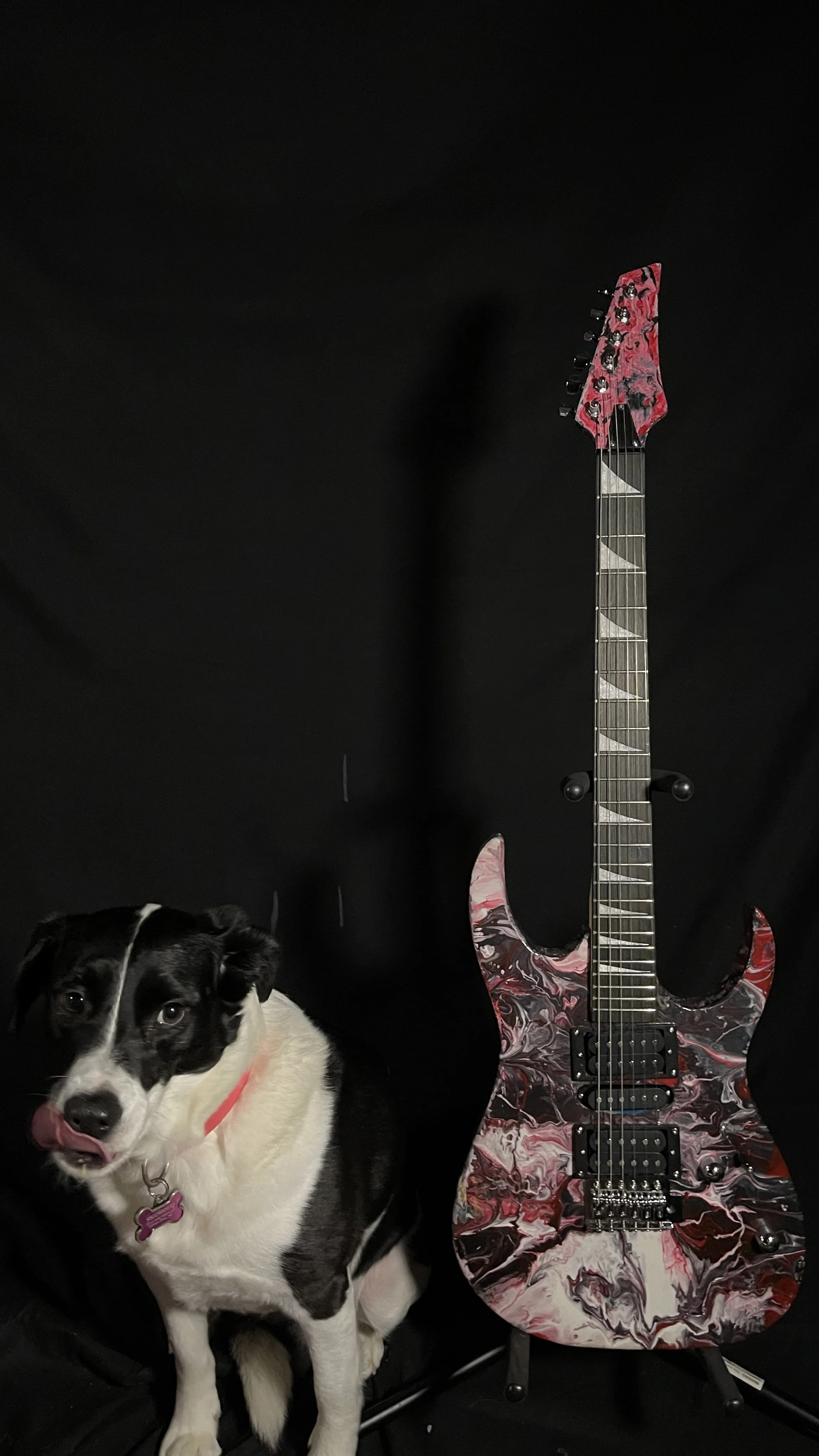 A pink, white and black acrylic poured electric guitar named Luna by Grainrot Guitars