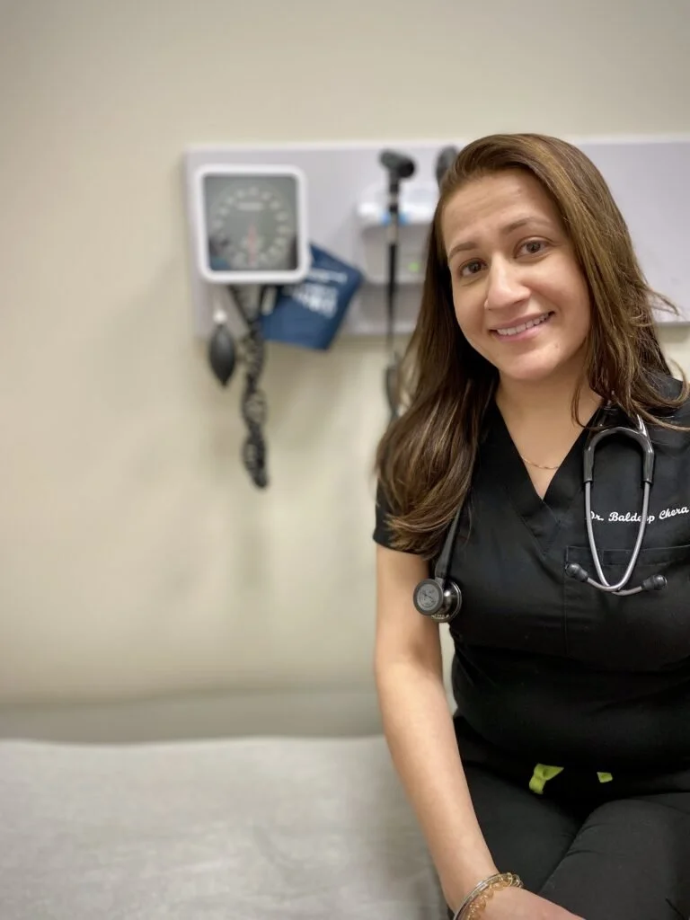 Photo of Dr. Chera with a stethescope in an exam room 