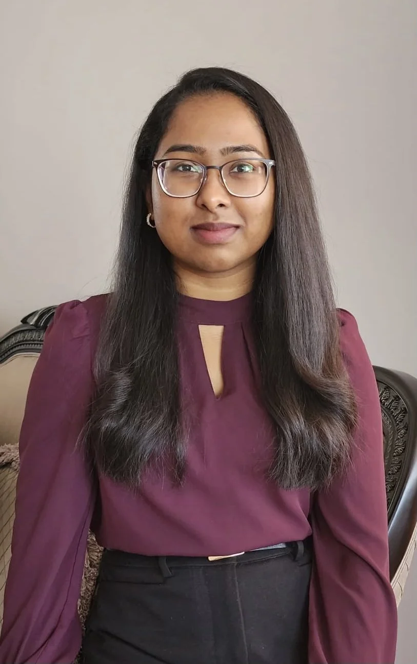 Photo of Dr. Kumar wearing a maroon top on a grey background