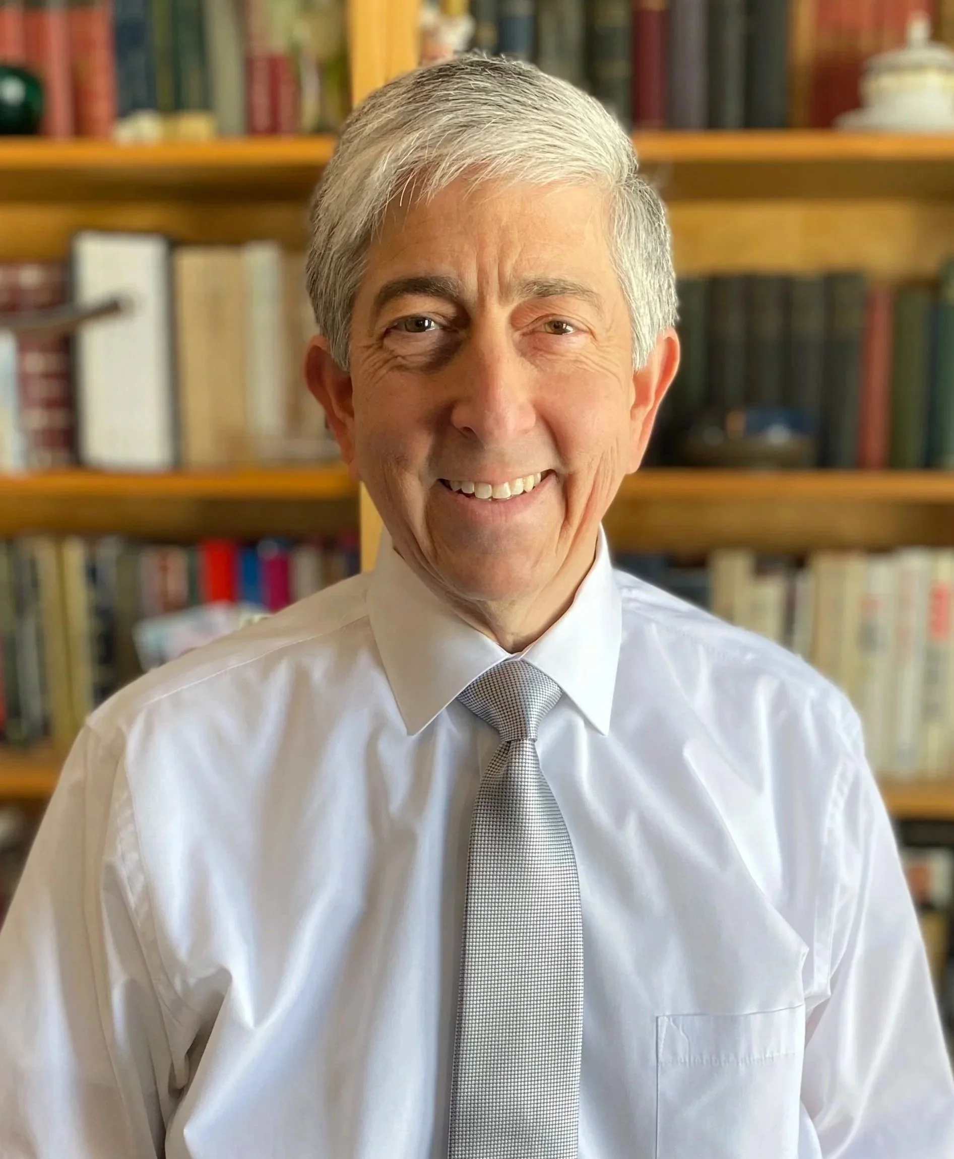 A photo of candidate Alec Stone smiling in front of a bookcase