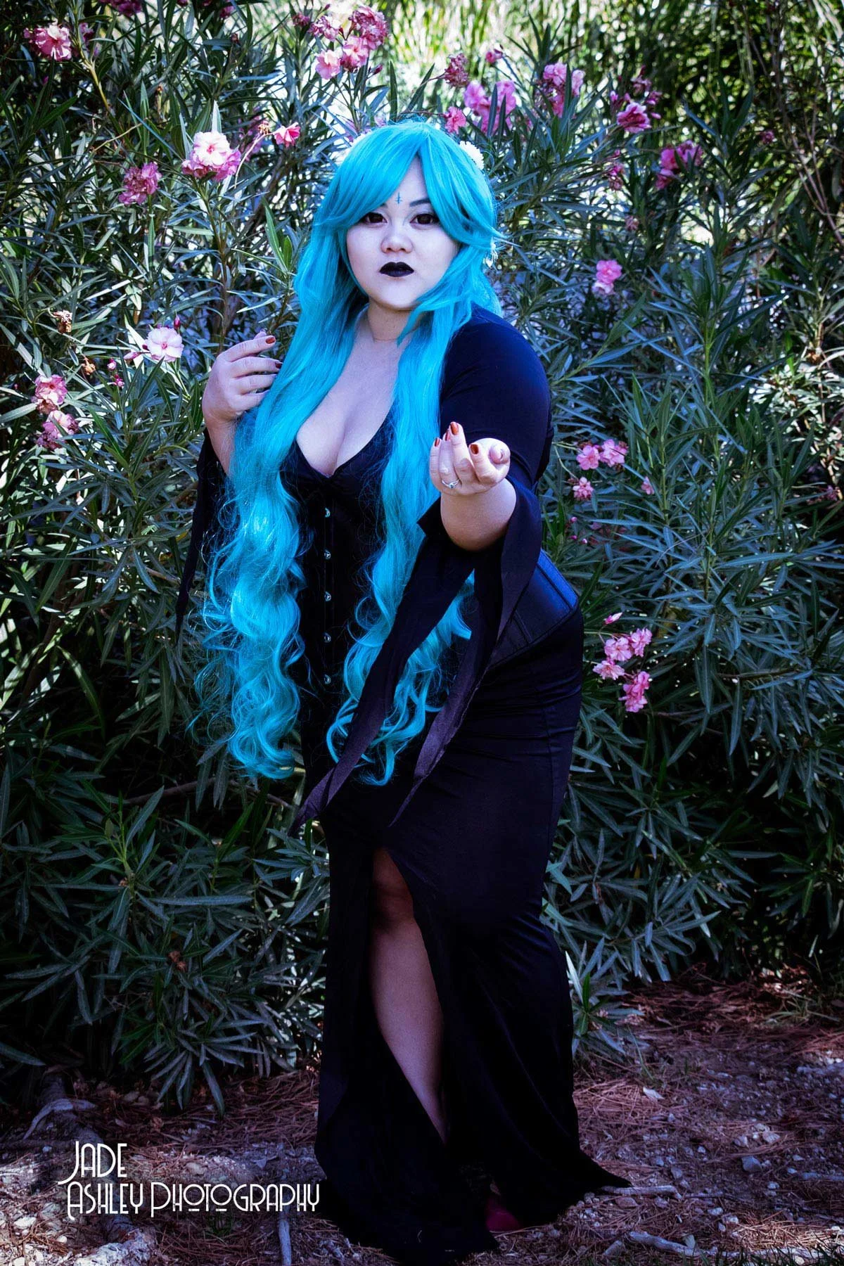 woman dressed in all black to resemble a witch with blue hair