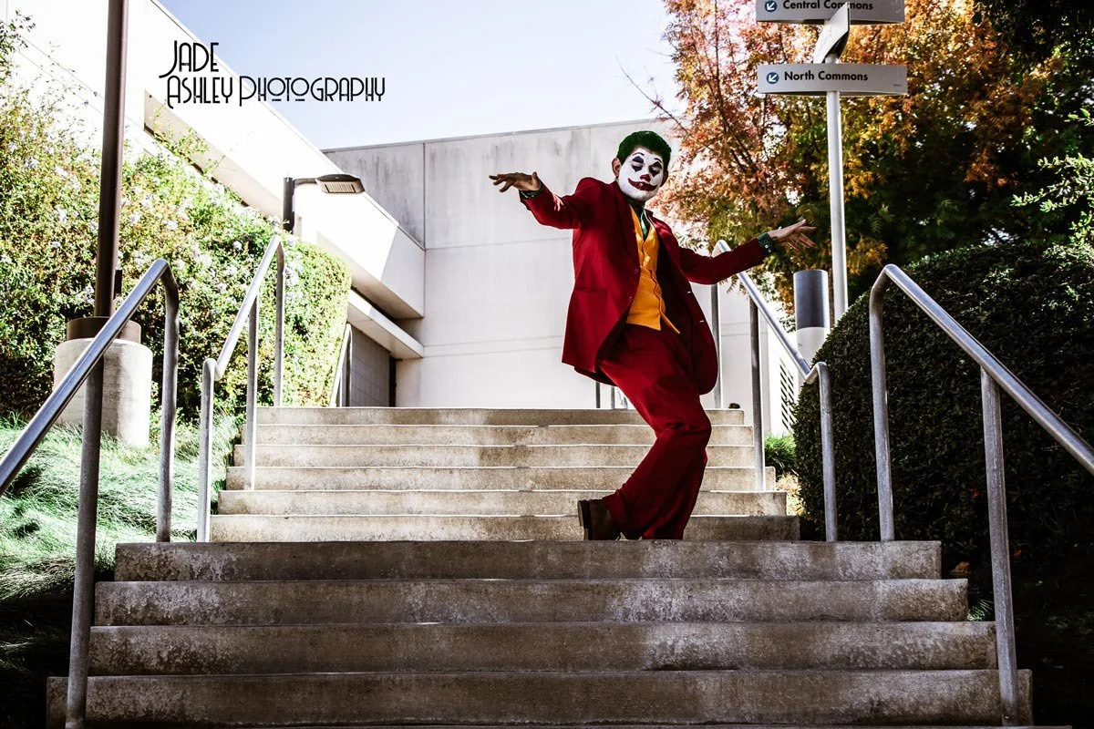 man dressed up as joker with outfit and makeup as a clown
