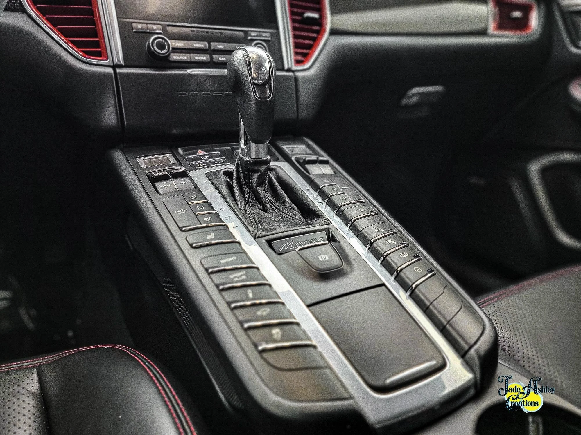 Center console of a Porsche Macan with gear shifter and multiple control buttons.