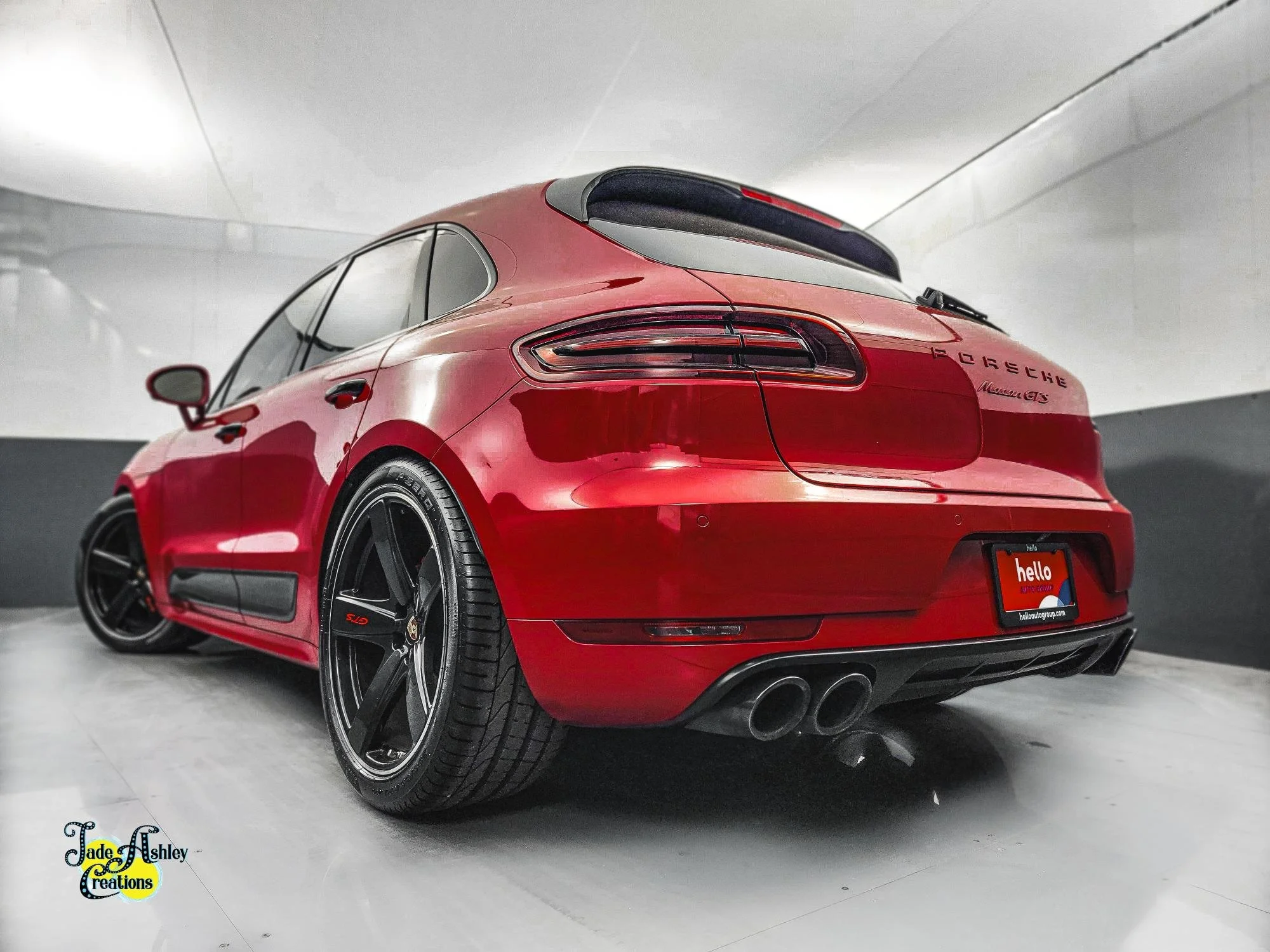 Red Porsche Macan GTS parked in an indoor parking garage, seen from the rear three-quarter angle.