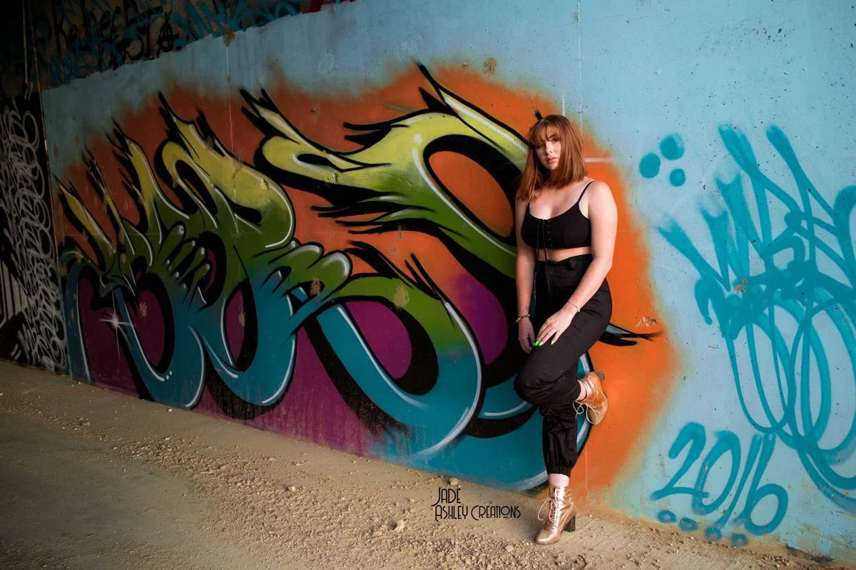 woman pose next to graffiti