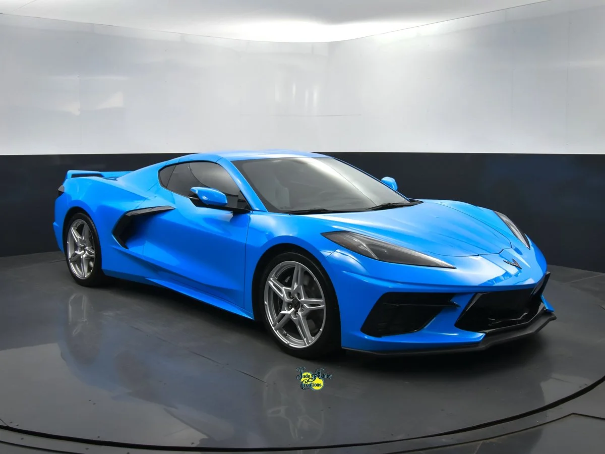 A bright blue sports car with sleek design and aerodynamic features is in an indoor showroom.