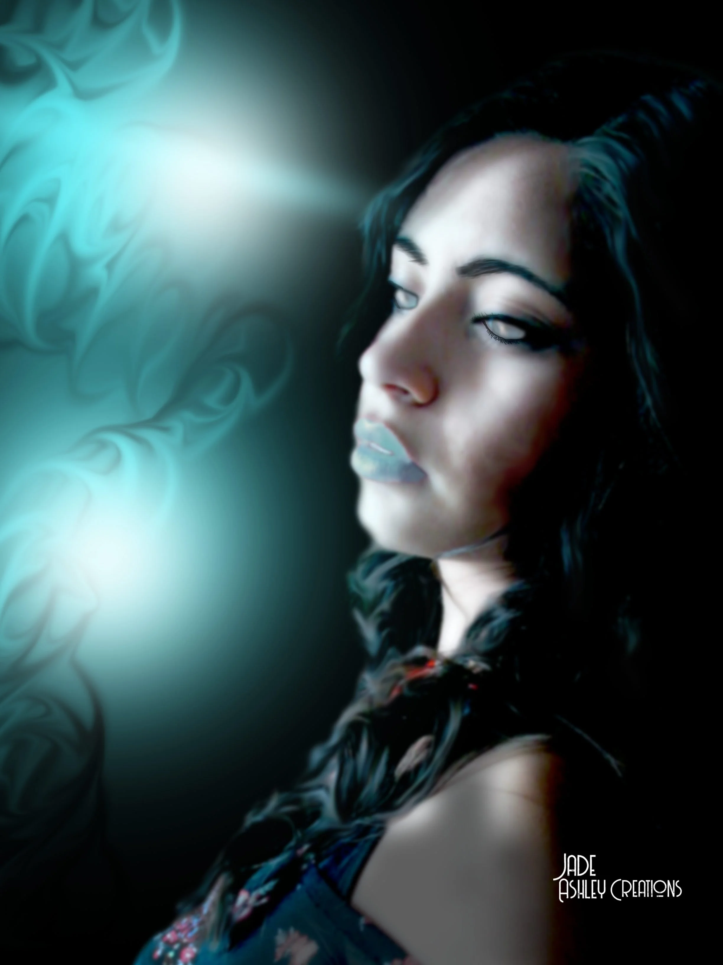 A woman with dark hair and light makeup gazes to the side against a dark background with glowing teal smoke and abstract patterns, with the text 'Jade Ashley Creations' in the lower right corner.