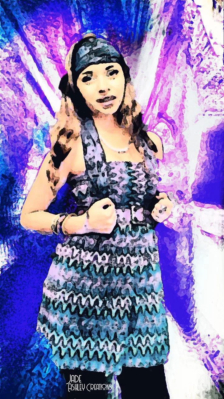 A woman with light brown hair, wearing a patterned dress and a headscarf, standing in front of a colorful abstract background.