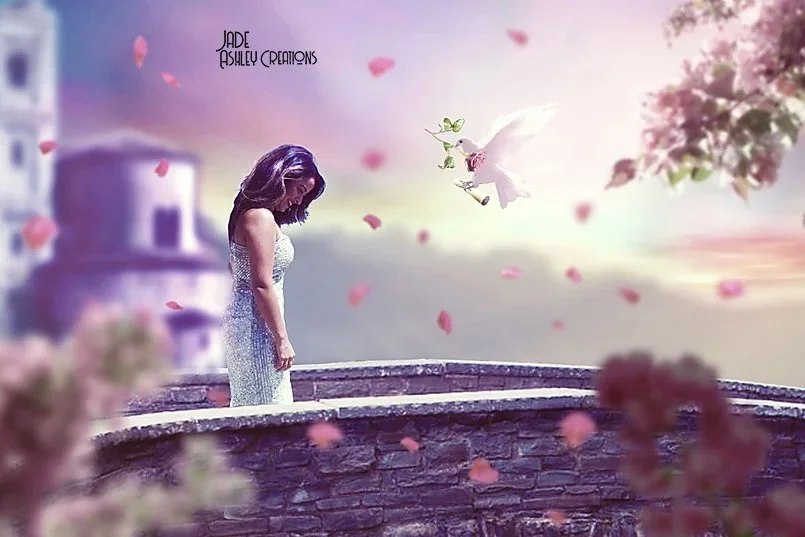 A woman in a white dress standing on a stone balcony overlooking a dreamy landscape with pink petals falling, a white dove flying, and a pink flowering tree on the right.