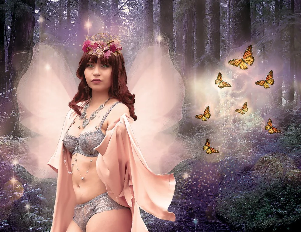 A woman dressed as a fairy with pink wings, wearing lingerie and a flower crown, standing in a magical forest with butterflies flying around.