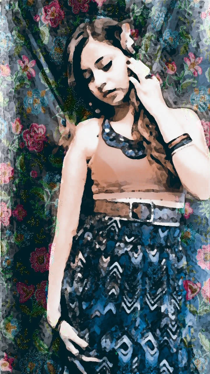 A young woman with long, wavy hair, posing with her eyes closed, amid a floral background with pink and purple flowers.