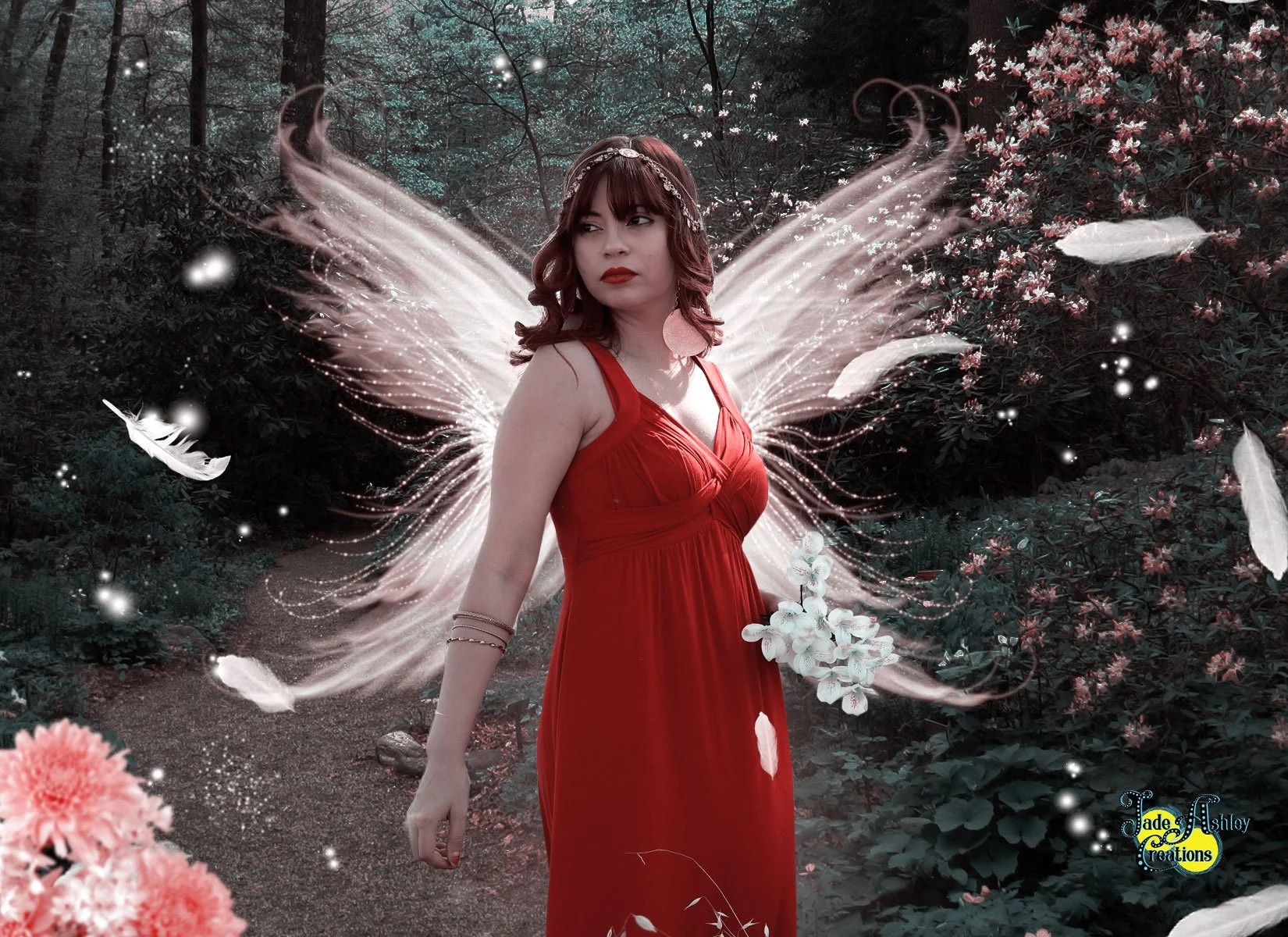 A woman in a red dress with fairy wings and flowers in her hair stands in a dark, wooded area with pink flowers and glowing feathers surrounding her.