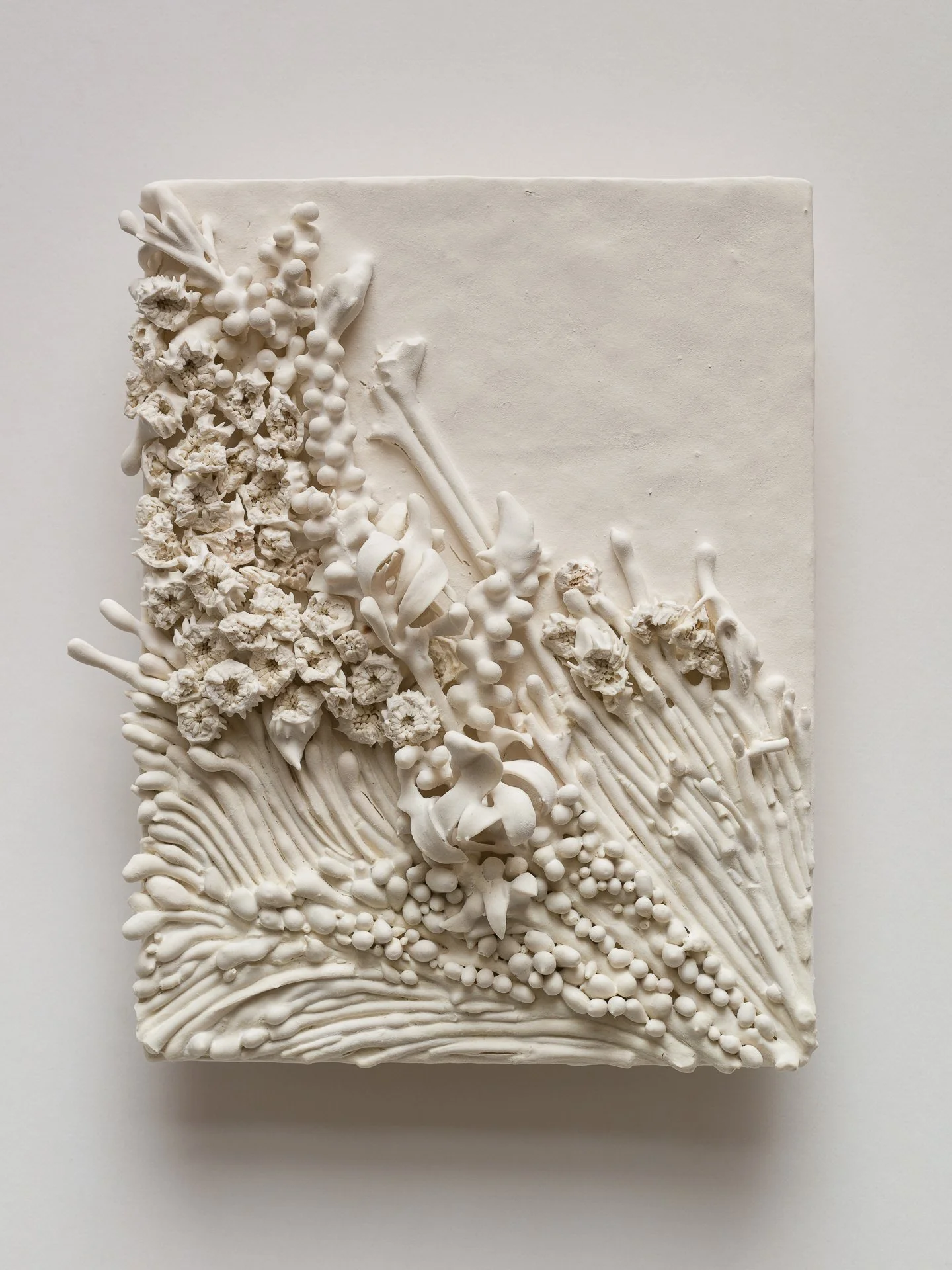 White rectangular art piece with textured floral and organic designs in relief.