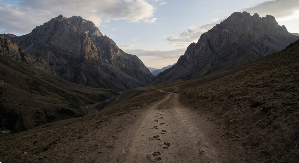 Footprints stopping in a mountain valley; a visual metaphor for trusting God and finding hope in difficult times.
