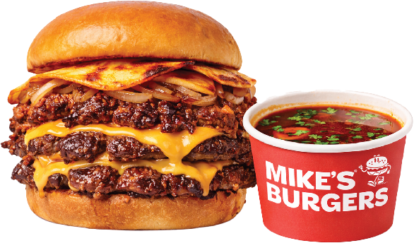 A cheeseburger with a toasted bun, lettuce, onions, summer sausage, multiple beef patties, melted cheese, topped with a fried egg, served with a cup of soup labeled Mike's Burgers.