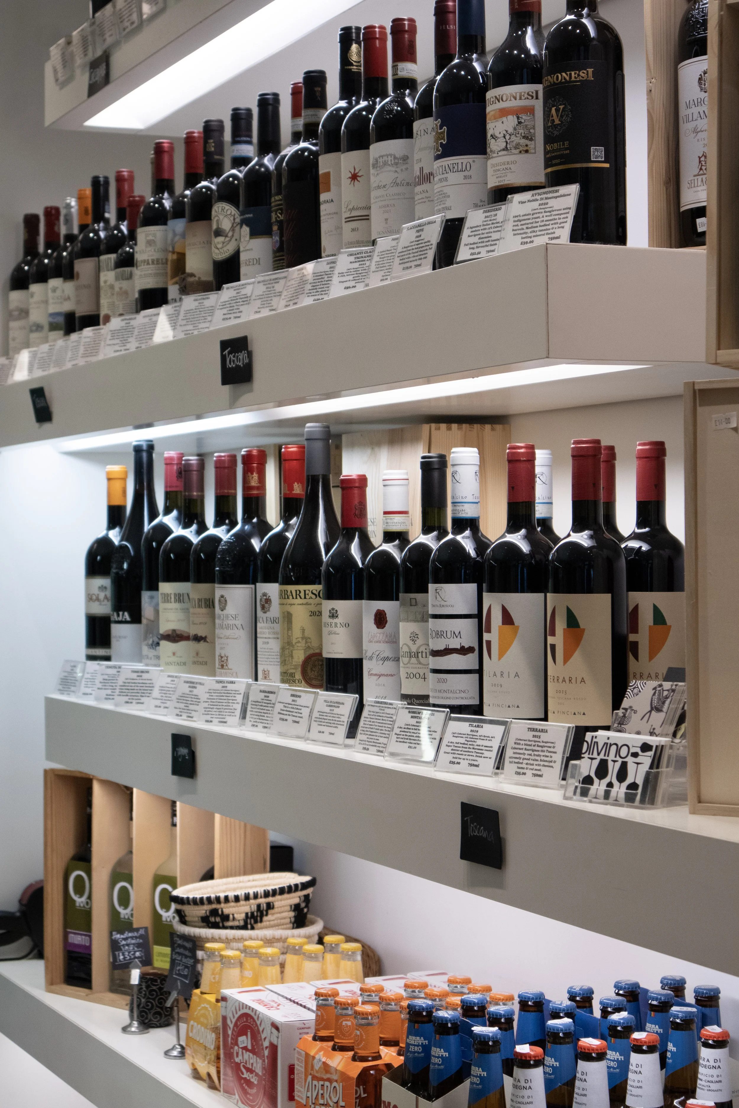 Shelves stocked with various bottles of wine, beer, and beverages in a retail store.