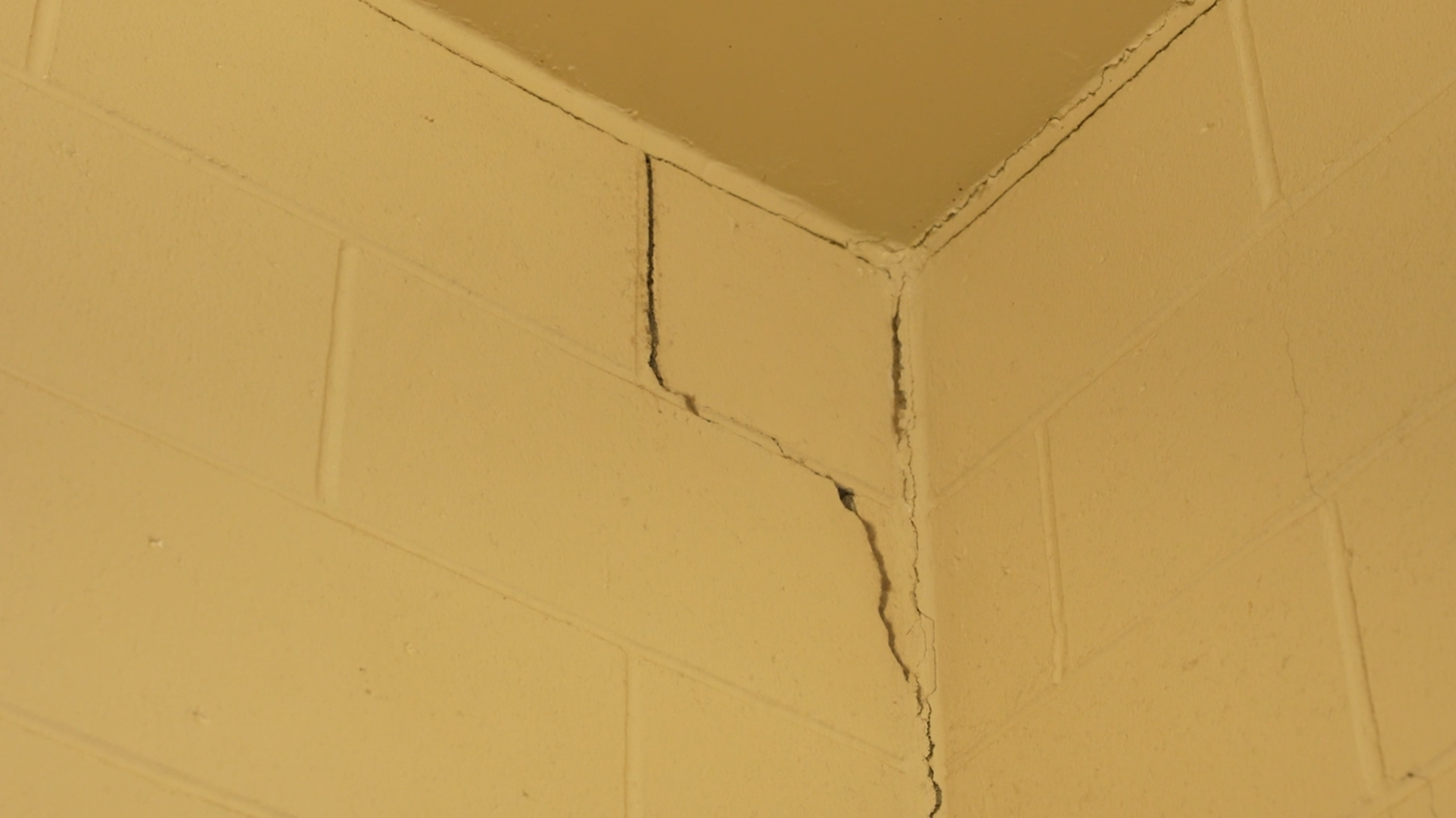 This crack is in a jail cell. In several areas, these cracks can be seen in the walls and in corners.