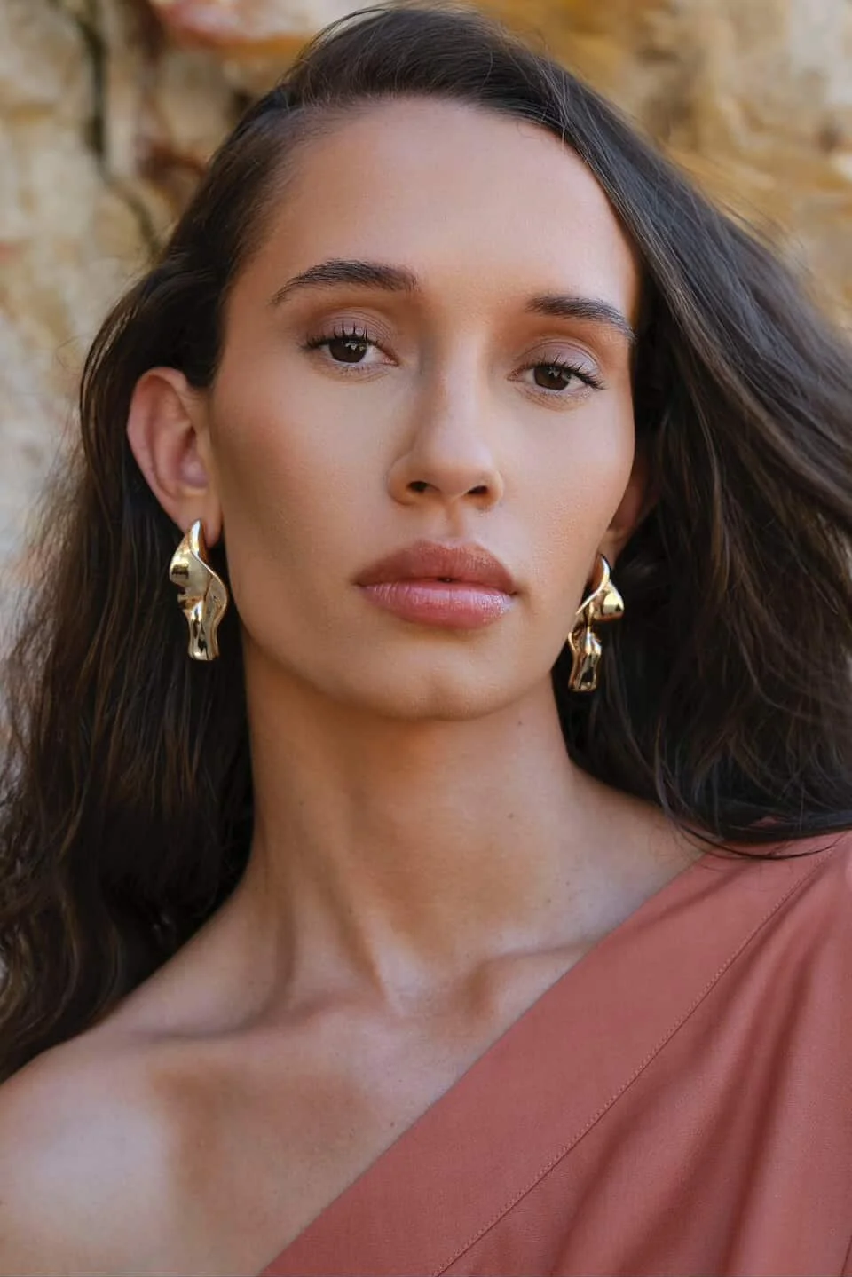 Close-up portrait of a model with professional editorial makeup, featuring shimmering eyeshadow and a bold lip, showcasing Archie’s artistry.