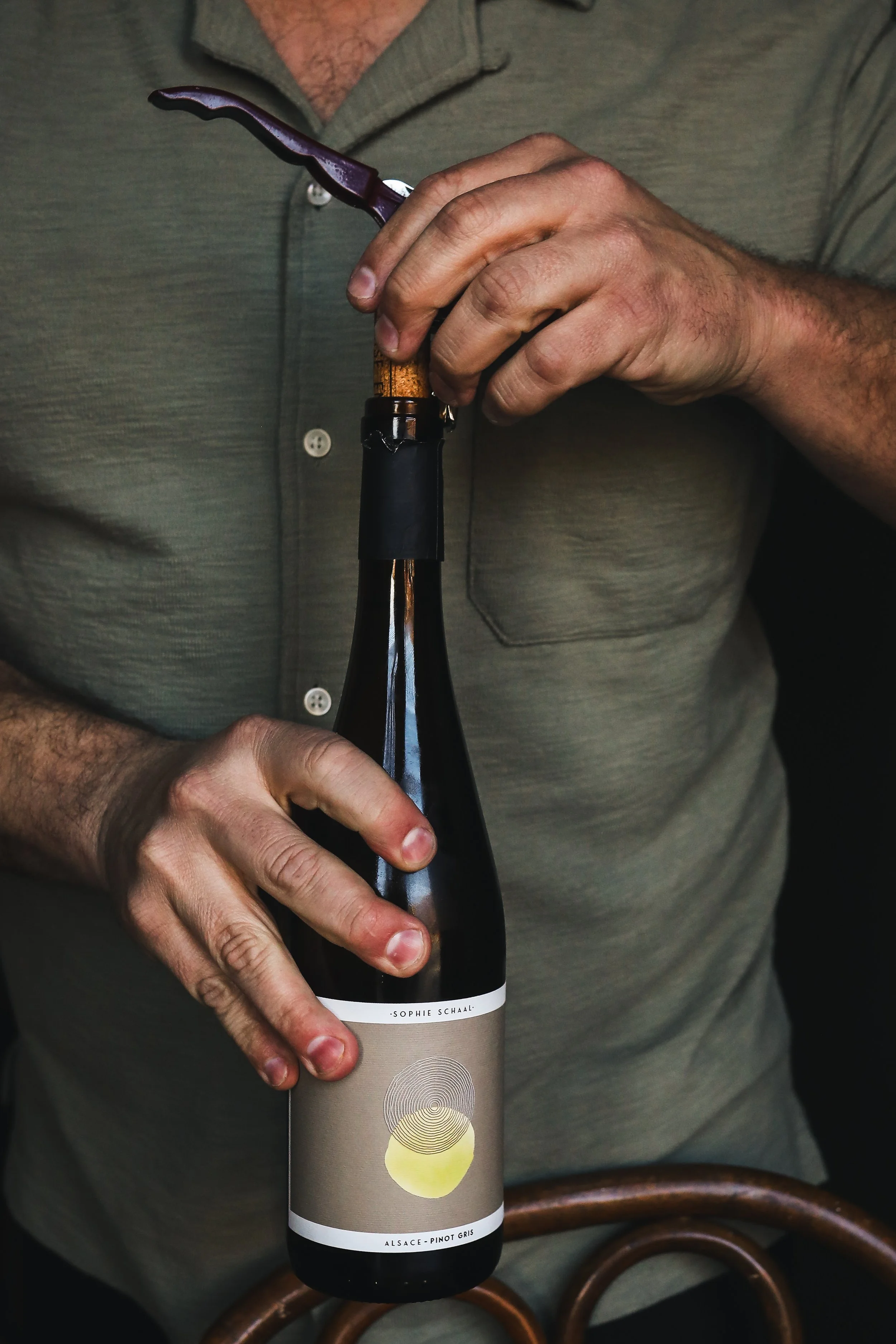 Hands opening wine bottle